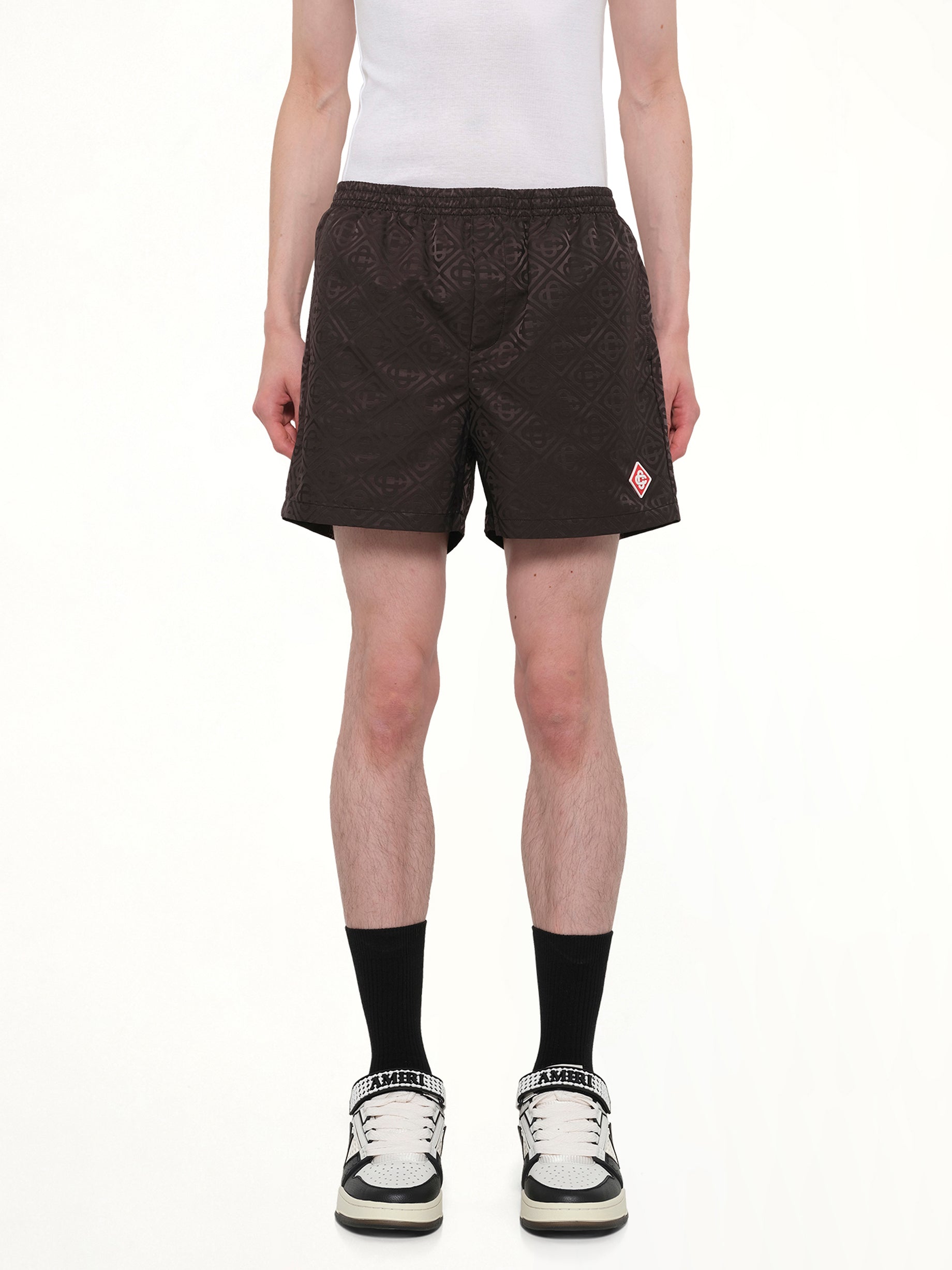 Image of a model wearing Shorts. Product name - Jacquard Swim Shorts in Black colour by brand - CASABLANCA
