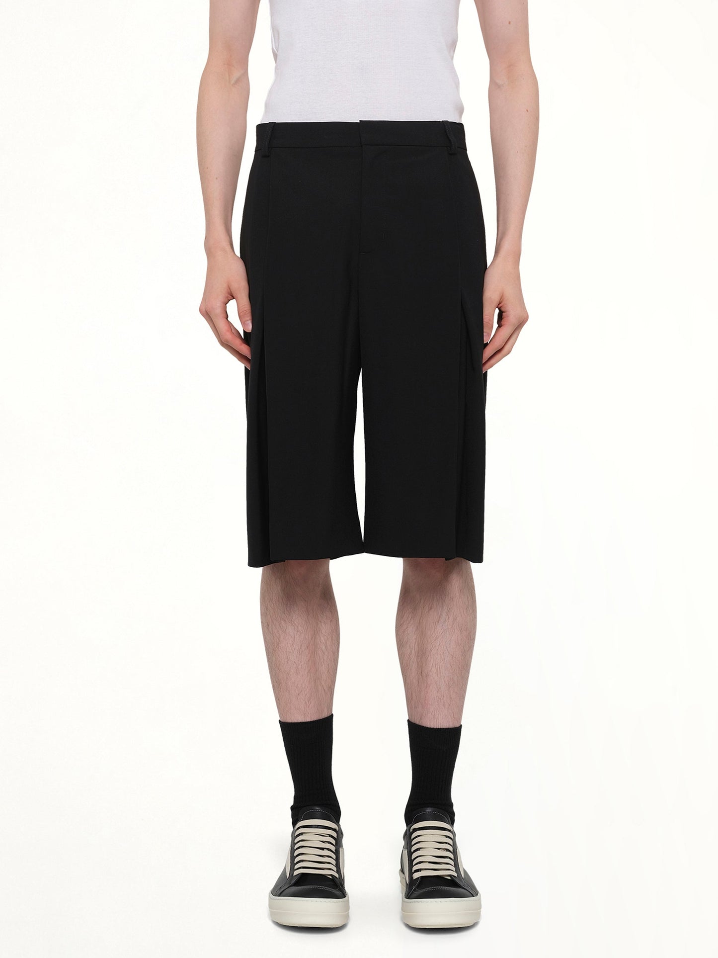 Image of a model wearing Shorts. Product name - Pleated Baggy Shorts in Black colour by brand - CASABLANCA