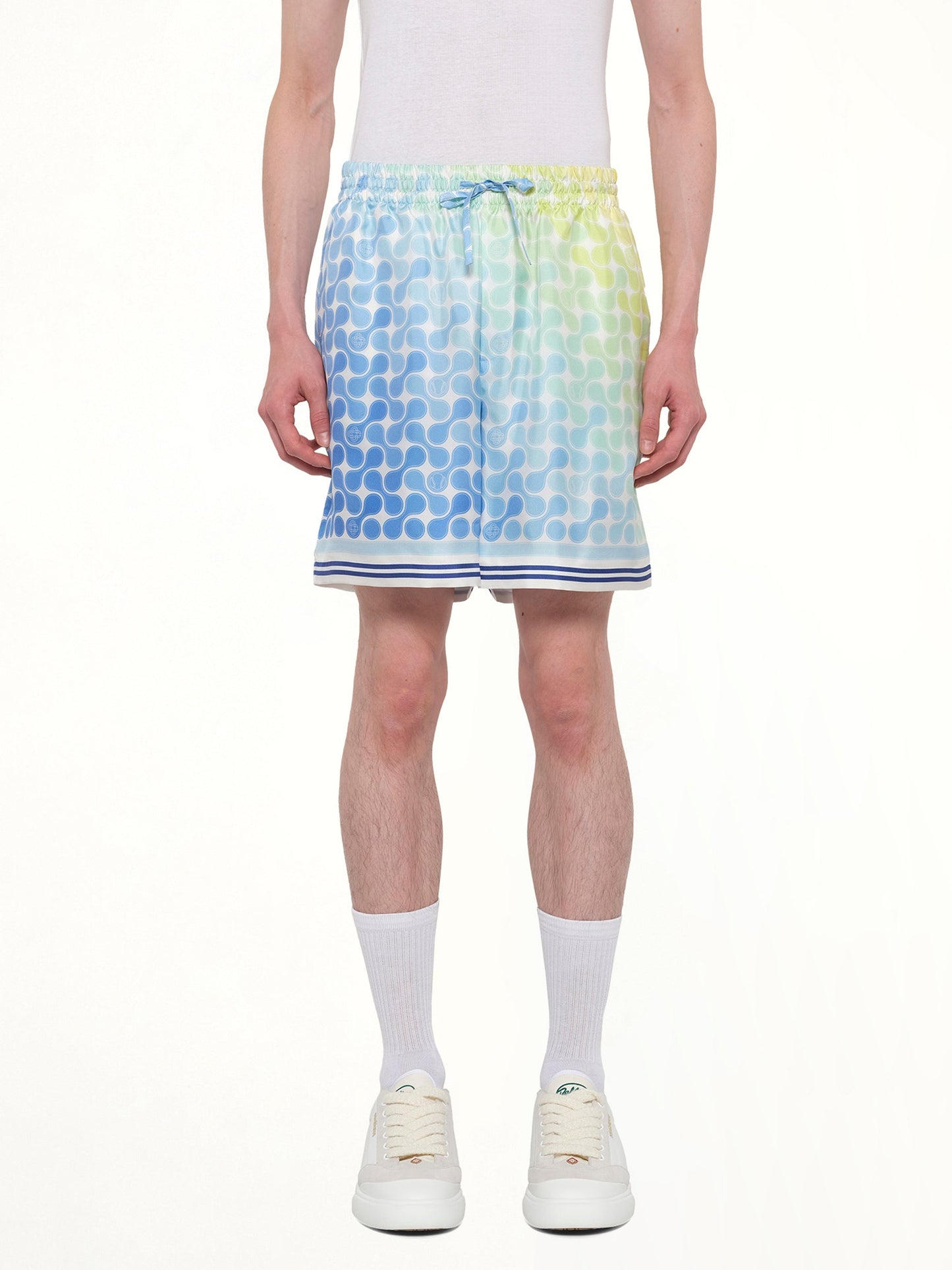Image of a model wearing Shorts. Product name - Tennis Tile Silk Shorts in Blue colour by brand - CASABLANCA