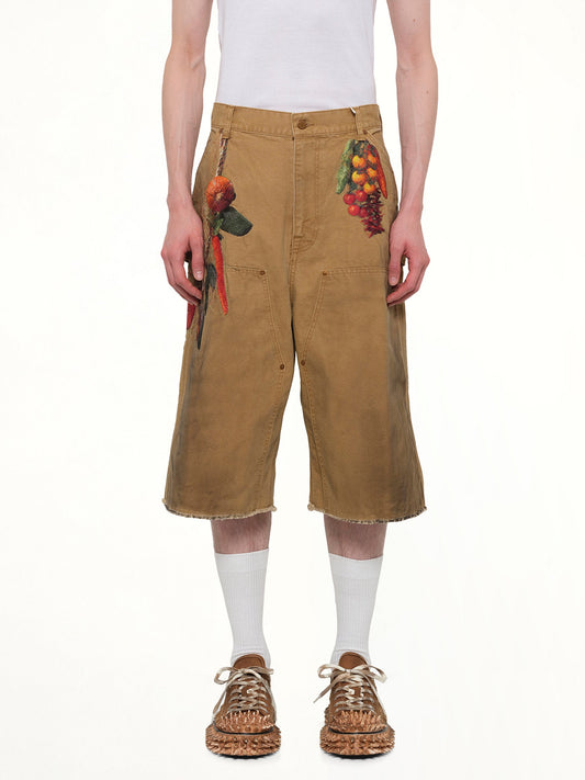 Image of a model wearing Shorts. Product name - Vegetable Embroidery Cut-Off Pants in Beige colour by brand - DOUBLET