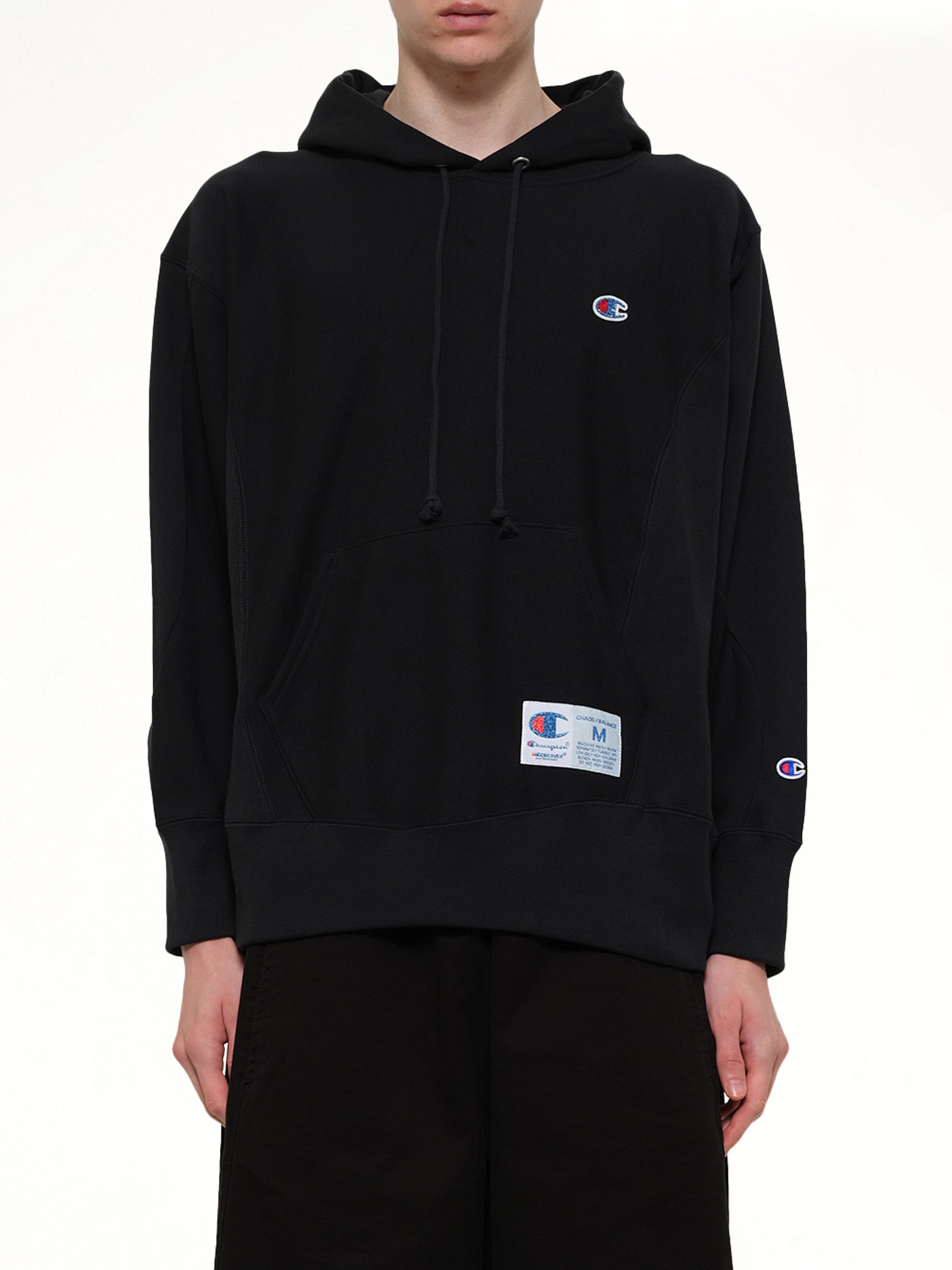 Image of a model wearing Outerwear. Product name - Champion x UC Hoodie in Black colour by brand - UNDERCOVER