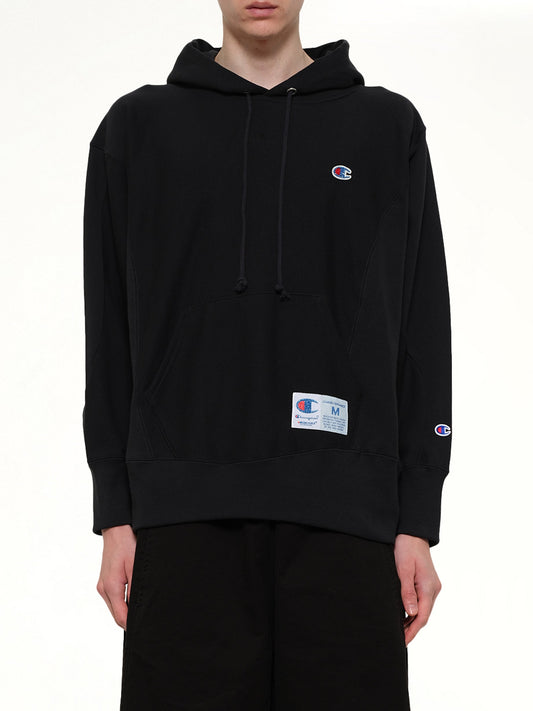 Image of a model wearing Outerwear. Product name - Champion x UC Hoodie in Black colour by brand - UNDERCOVER