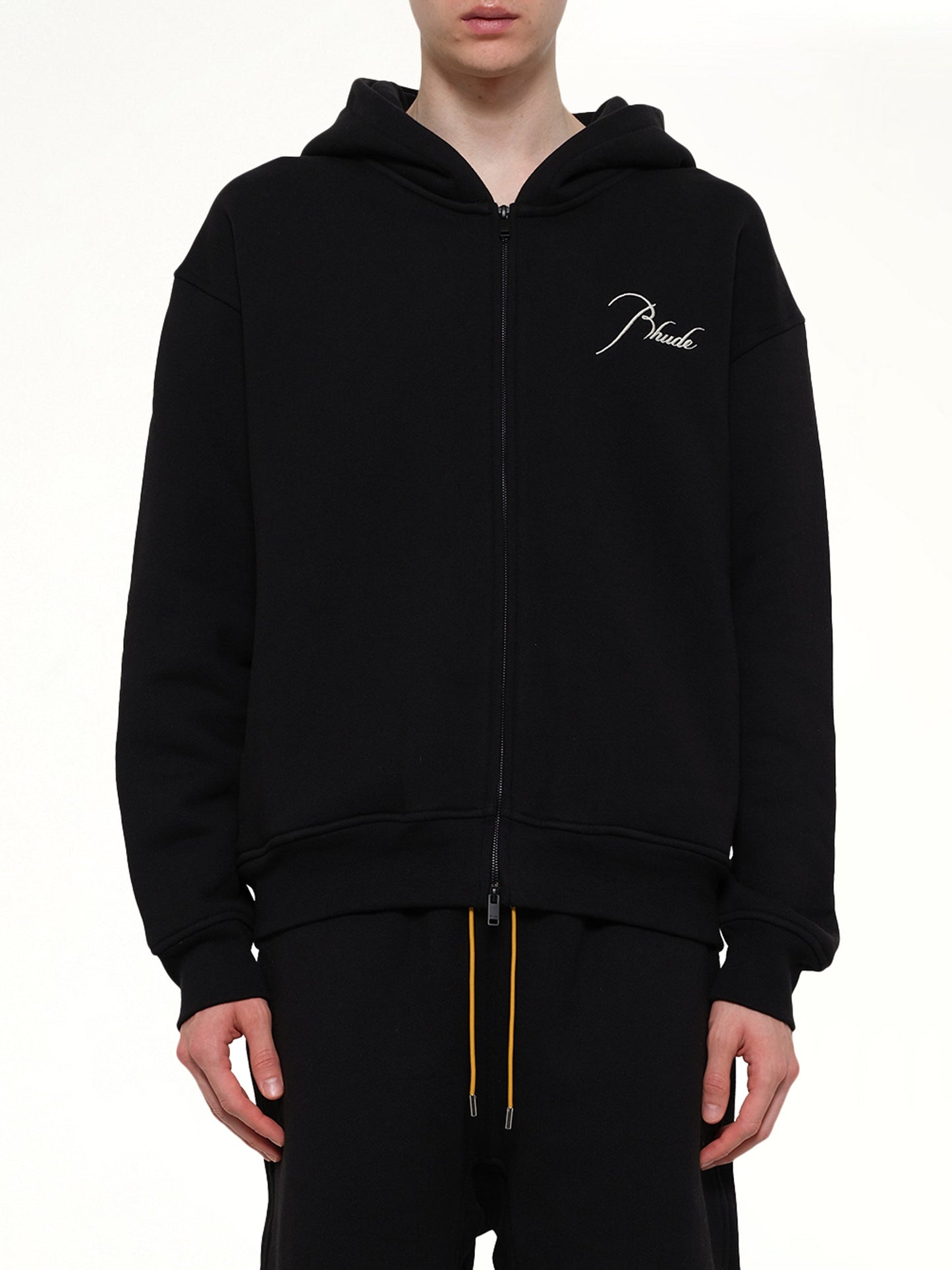 Image of a model wearing Outerwear. Product name - Classique Zip Up Hoodie in Black colour by brand - RHUDE