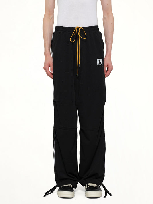 Image of a model wearing Pants. Product name - Rhude Mesh Piping Parachute Track Pant in Black colour by brand - RHUDE