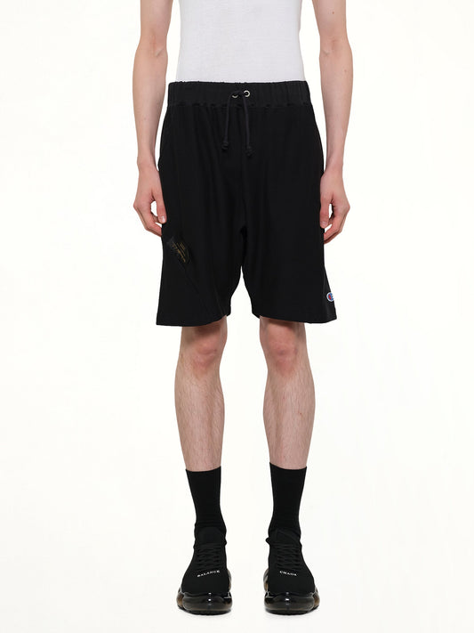 Image of a model wearing Shorts. Product name - Champion x UC Sweatshorts in Black colour by brand - UNDERCOVER
