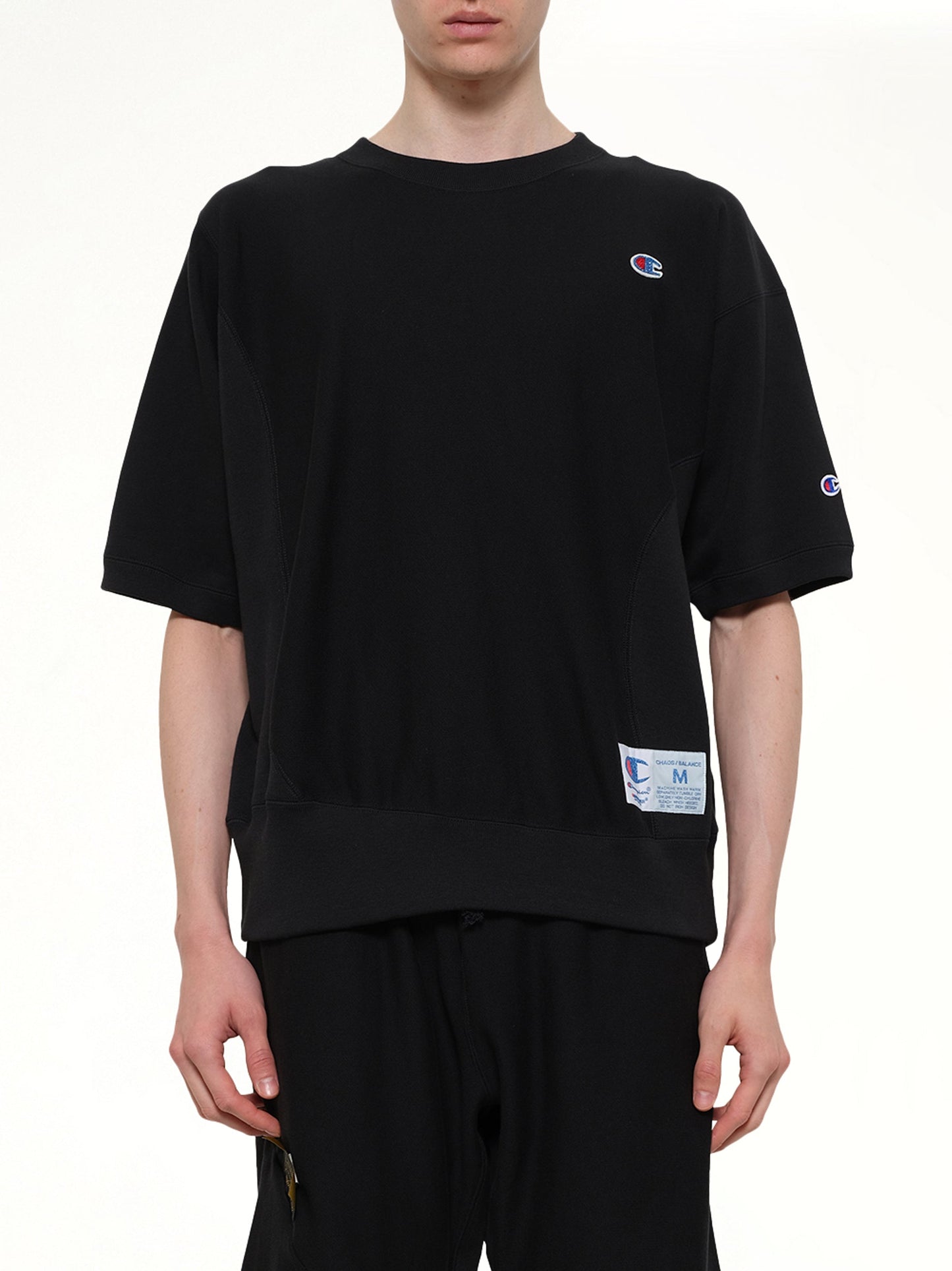 Image of a model wearing Outerwear. Product name - Champion x UC Sweat Top in Black colour by brand - UNDERCOVER