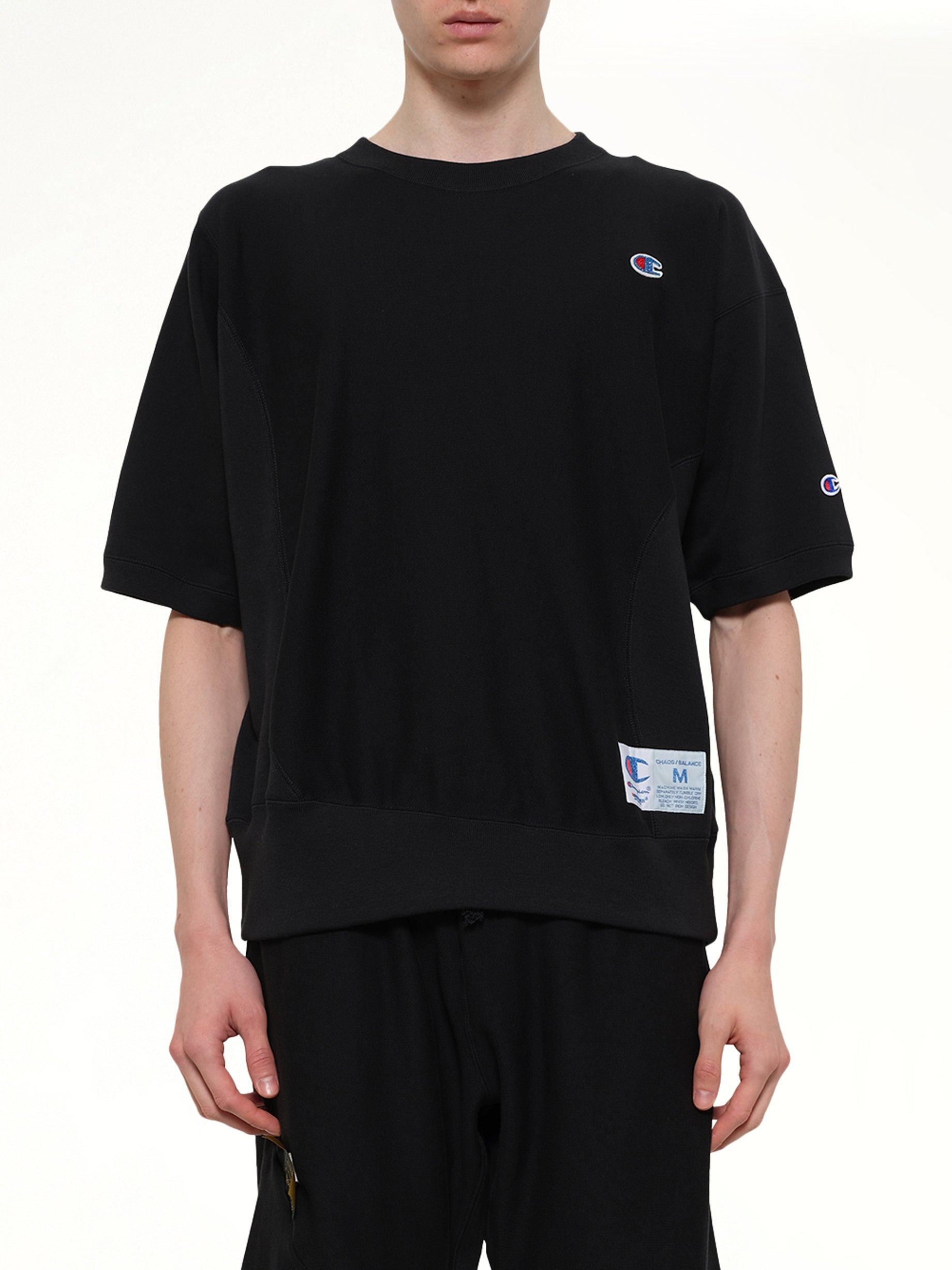 Image of a model wearing Outerwear. Product name - Champion x UC Sweat Top in Black colour by brand - UNDERCOVER