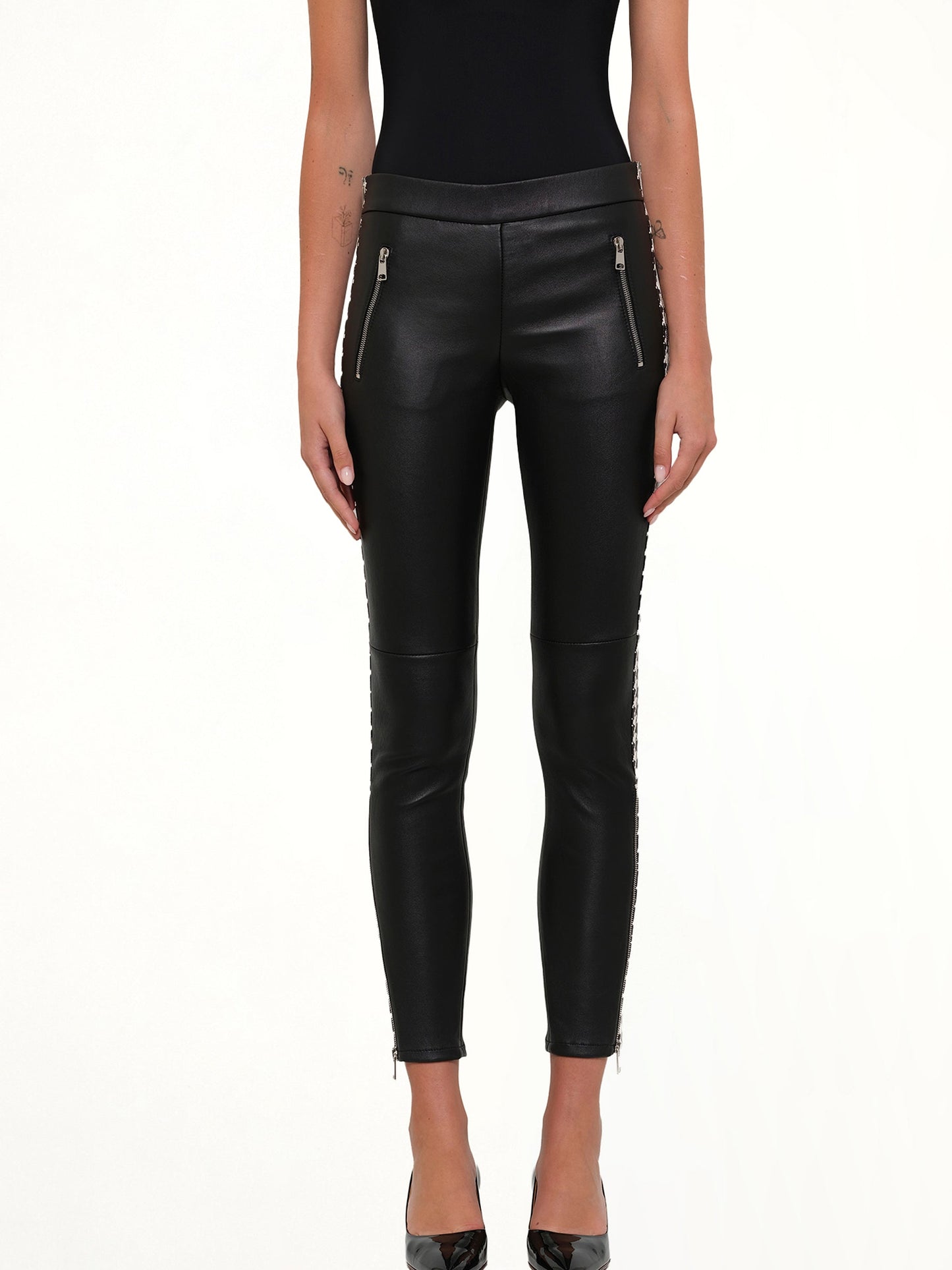 Image of a model wearing Pants. Product name - Leather Leggings in Black colour by brand - ALEXANDER MCQUEEN