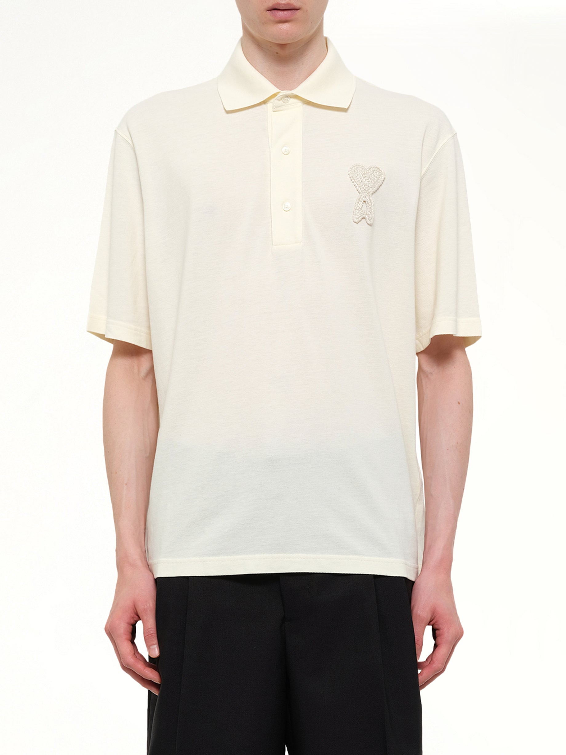 Image of a model wearing Tops. Product name - Knitted ADC Boxy Polo in White colour by brand - AMI PARIS