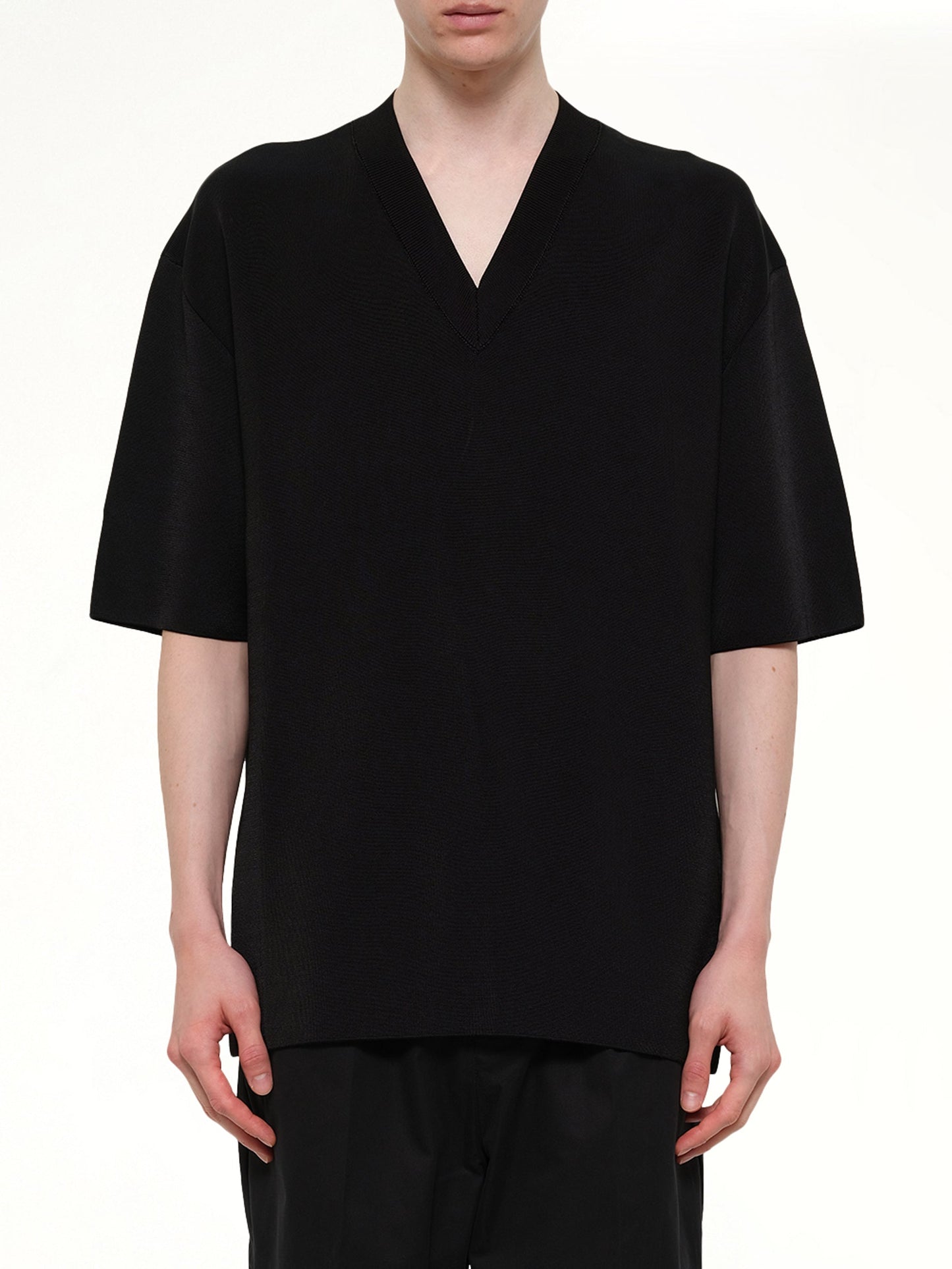Image of a model wearing Outerwear. Product name - Short Sleeve V-Neck Sweater in Black colour by brand - AMI PARIS