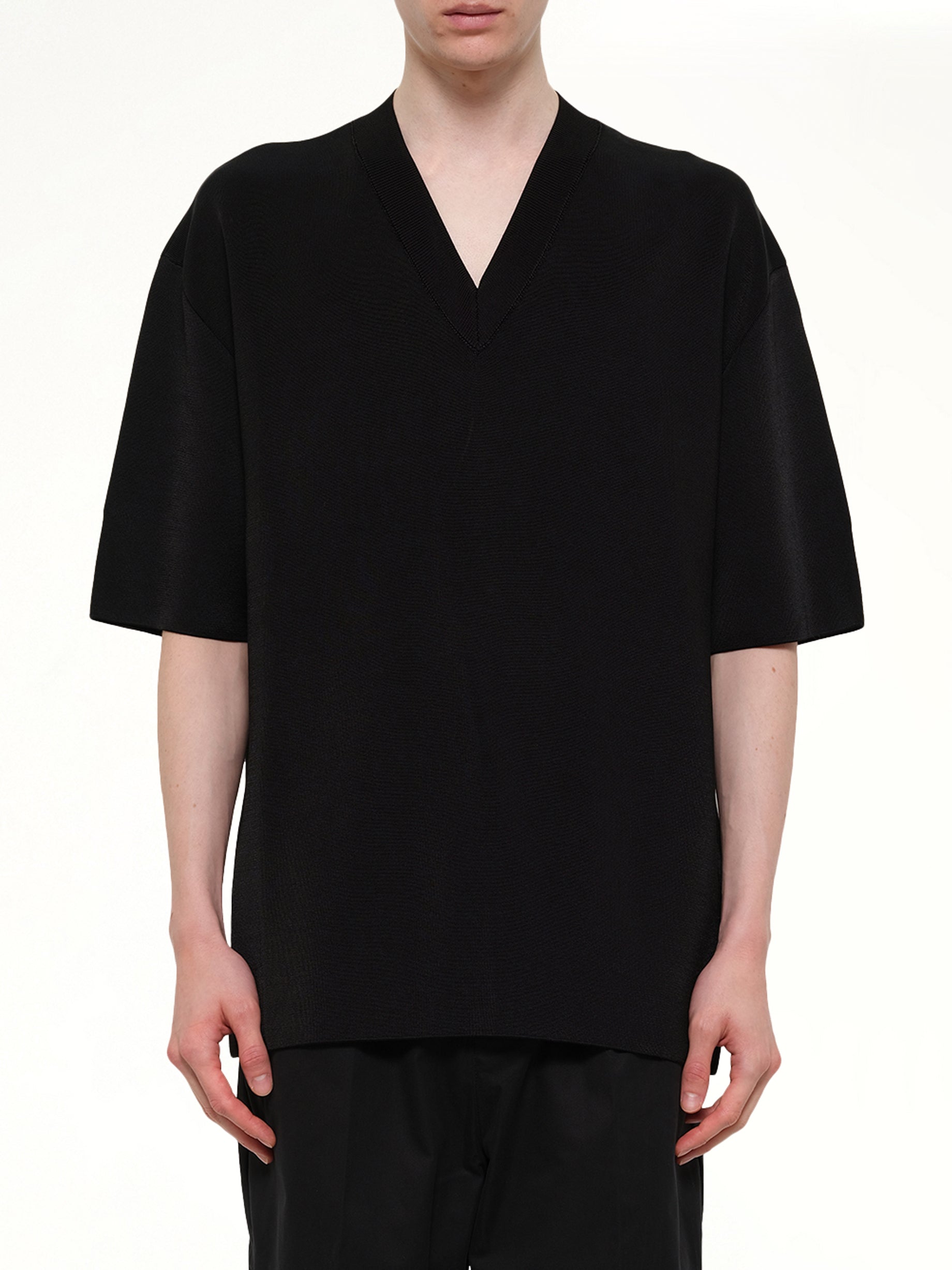 Image of a model wearing Outerwear. Product name - Short Sleeve V-Neck Sweater in Black colour by brand - AMI PARIS
