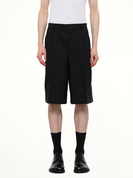 Image of a model wearing Shorts. Product name - Low Waist Wide Bermuda Shorts in Black colour by brand - AMI PARIS