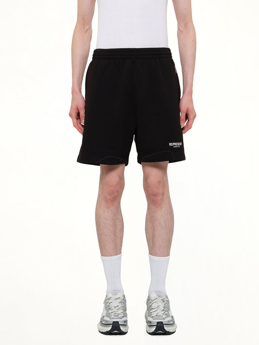 Image of a model wearing Shorts. Product name - Represent Owners Club Shorts in Black colour by brand - REPRESENT