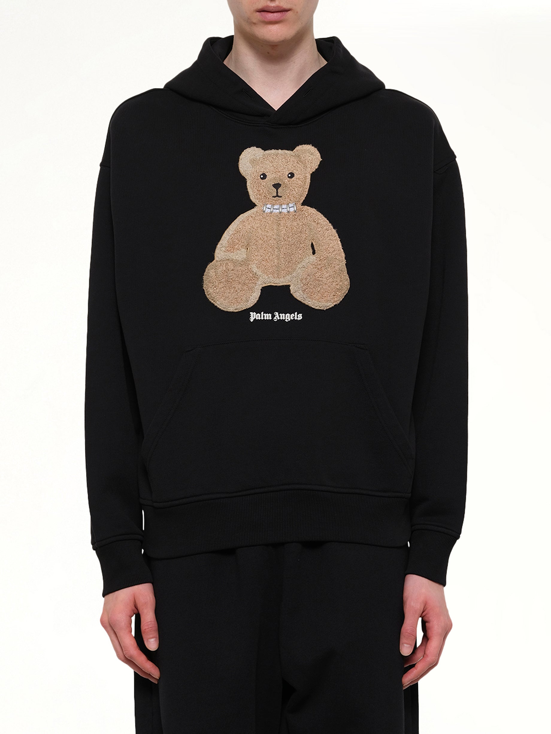 Image of a model wearing Outerwear. Product name - Bear Regular Hoodie in Black colour by brand - PALM ANGELS