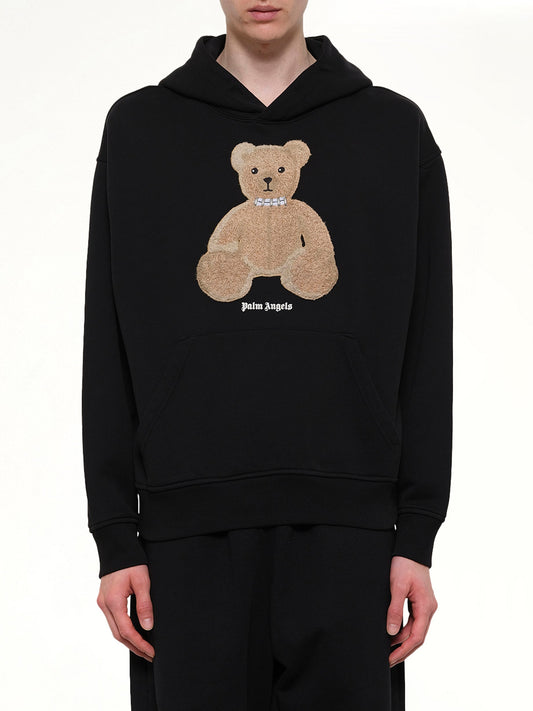 Image of a model wearing Outerwear. Product name - Bear Regular Hoodie in Black colour by brand - PALM ANGELS
