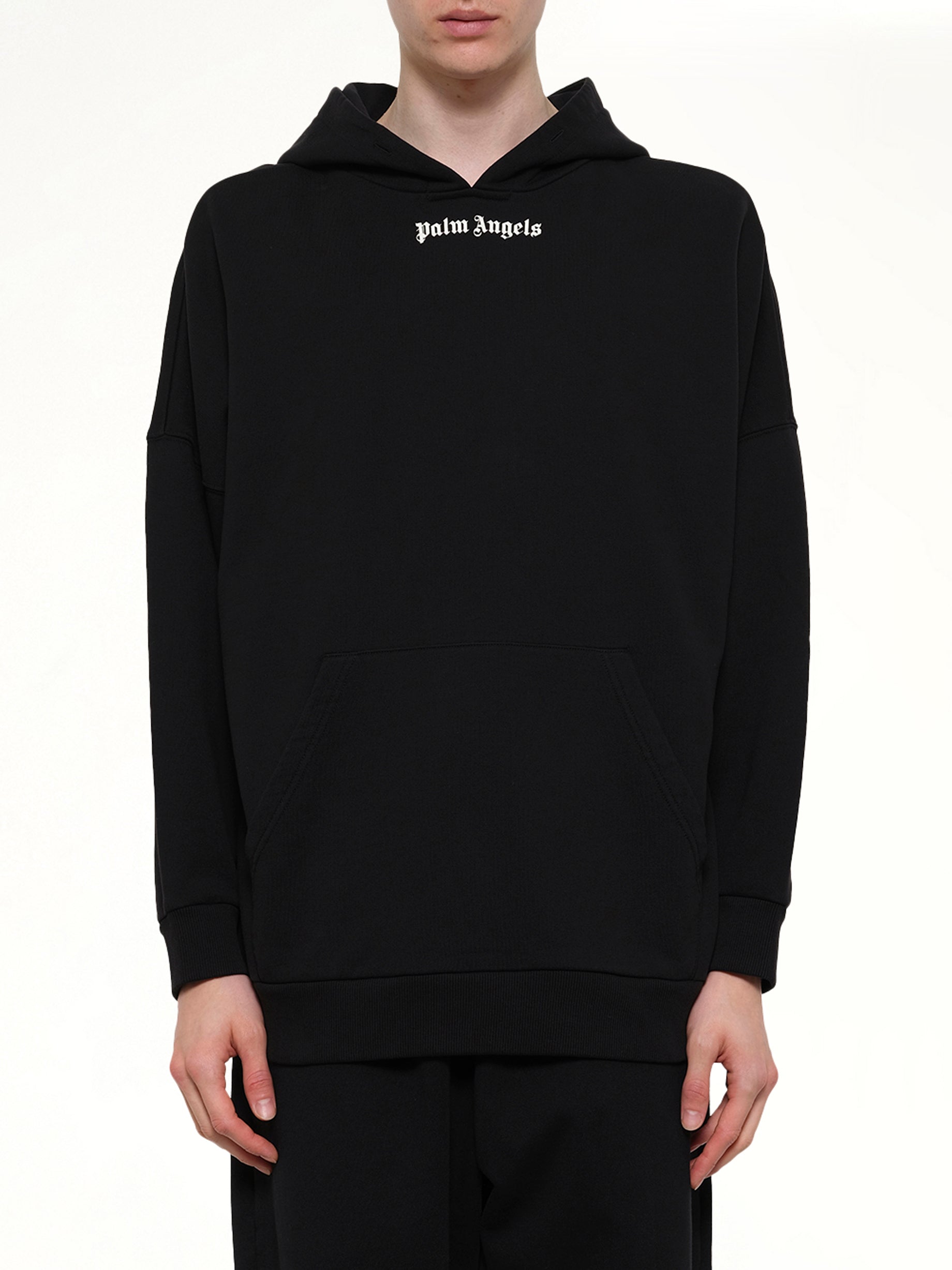 Image of a model wearing Outerwear. Product name - Classic Logo Over Hoodie in Black colour by brand - PALM ANGELS