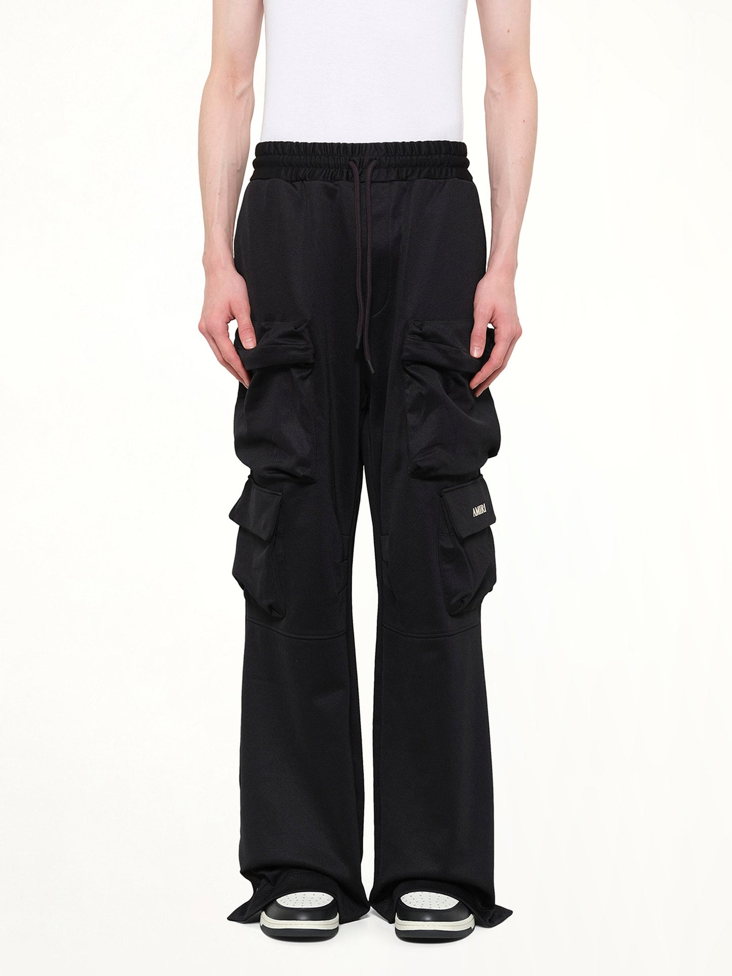 Image of a model wearing Pants. Product name - Cargo Track Pants in Black colour by brand - AMIRI