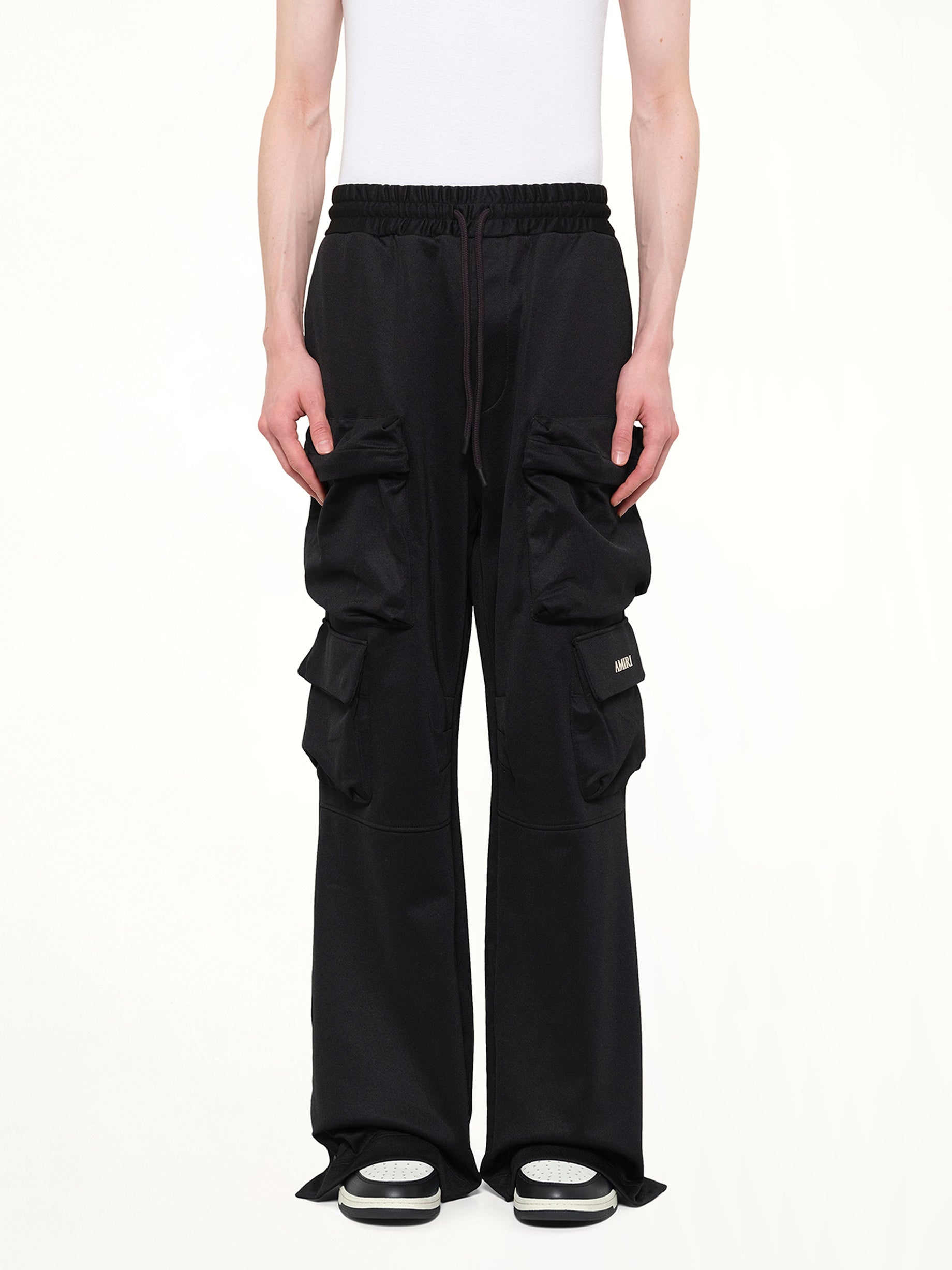 Image of a model wearing Pants. Product name - Cargo Track Pants in Black colour by brand - AMIRI