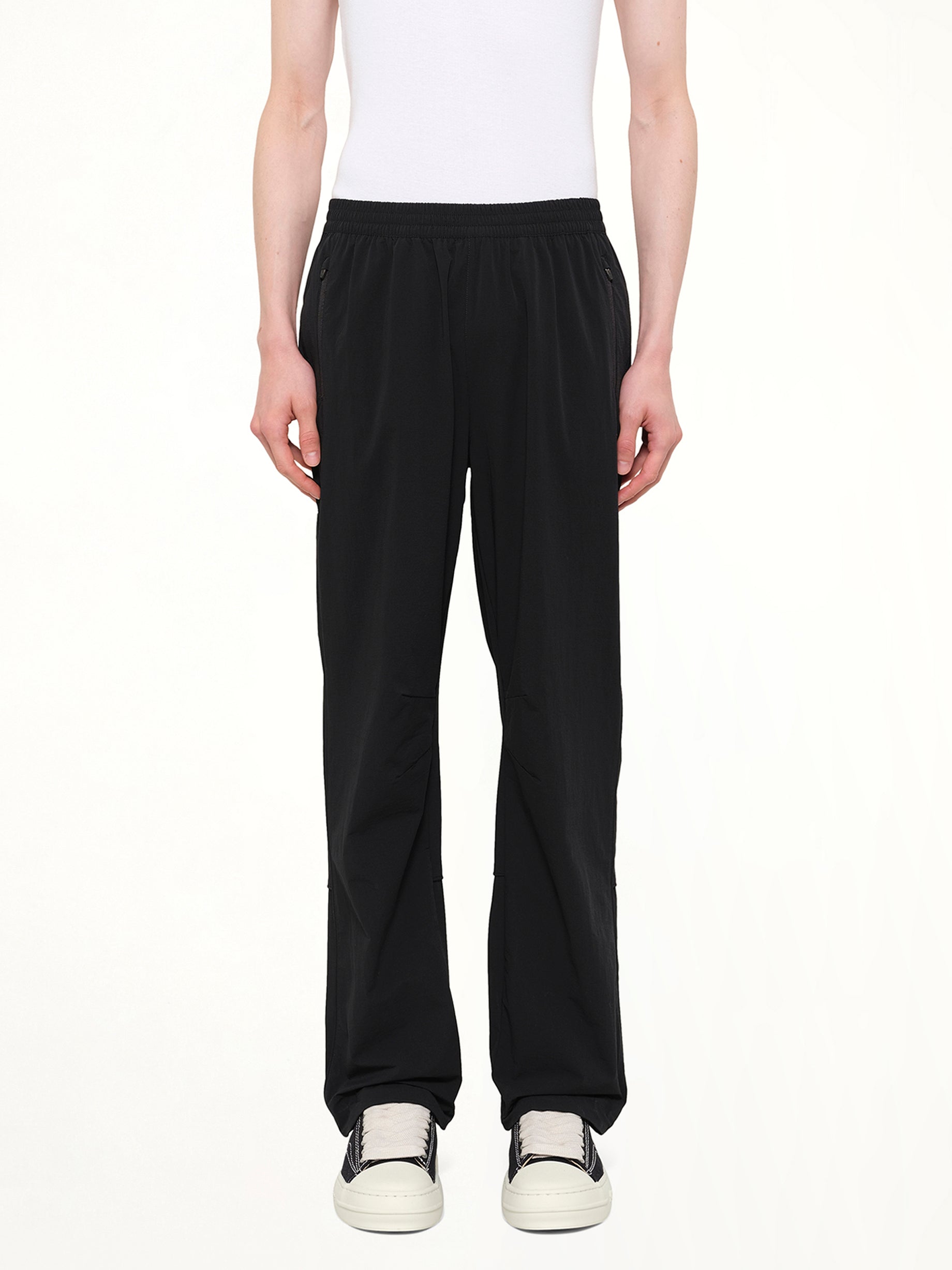 Image of a model wearing Pants. Product name - Team 247 Straight Leg Track Pant in Black colour by brand - REPRESENT