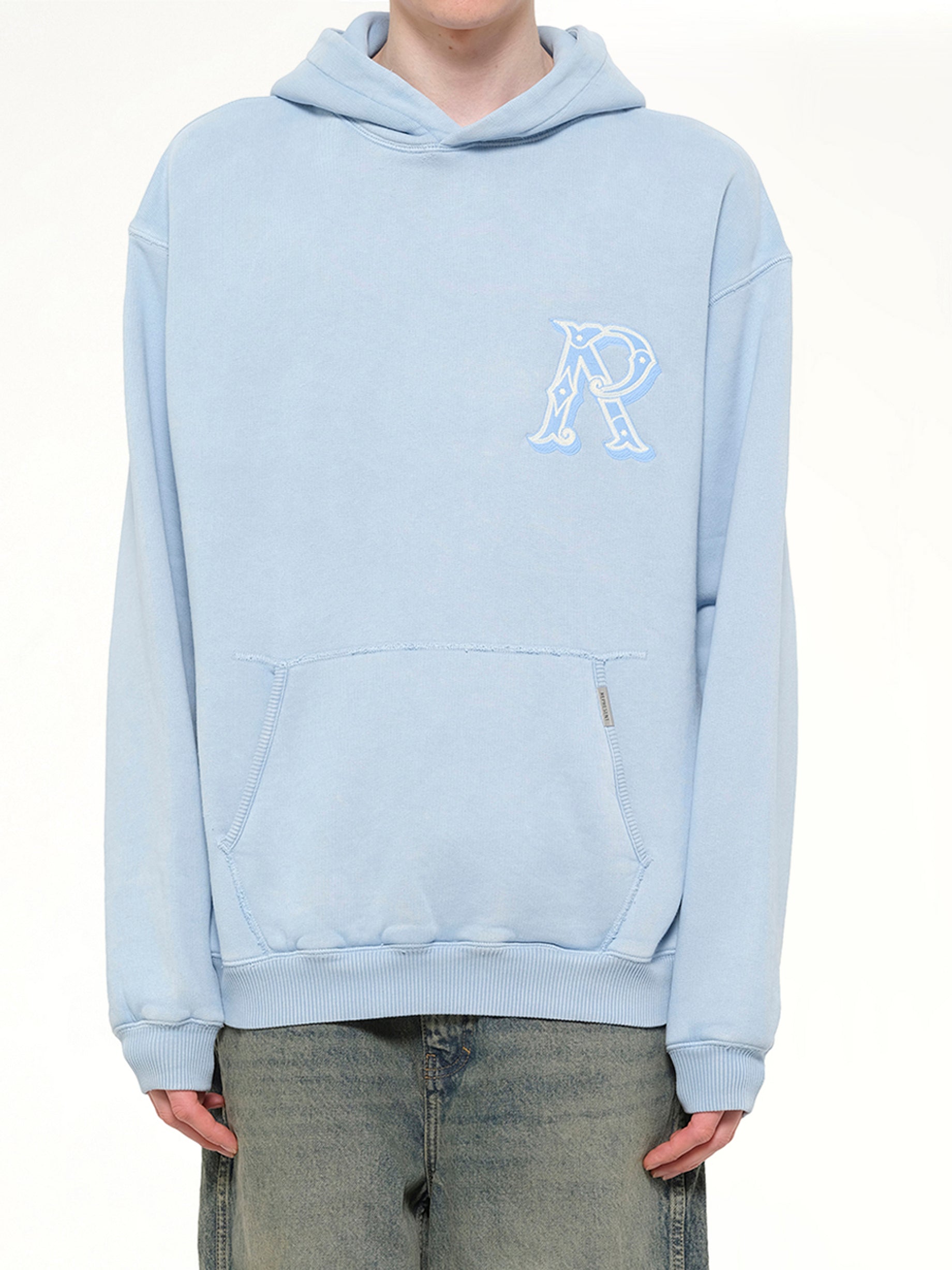 Image of a model wearing Outerwear. Product name - Western Initial Hoodie in Blue colour by brand - REPRESENT