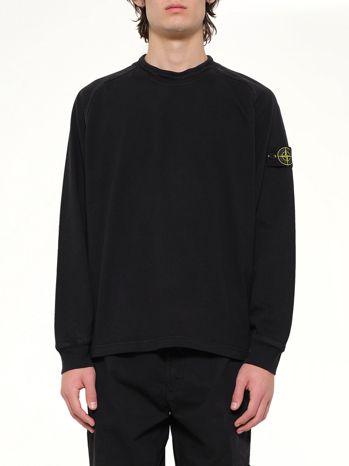 Image of a model wearing Outerwear. Product name - 6100030 Sweatshirt in Black colour by brand - STONE ISLAND
