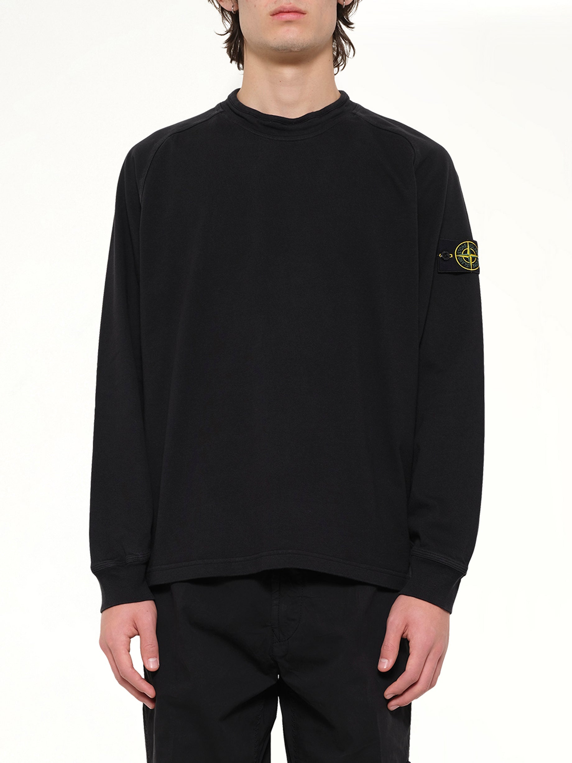 Image of a model wearing Outerwear. Product name - 6100030 Sweatshirt in Black colour by brand - STONE ISLAND