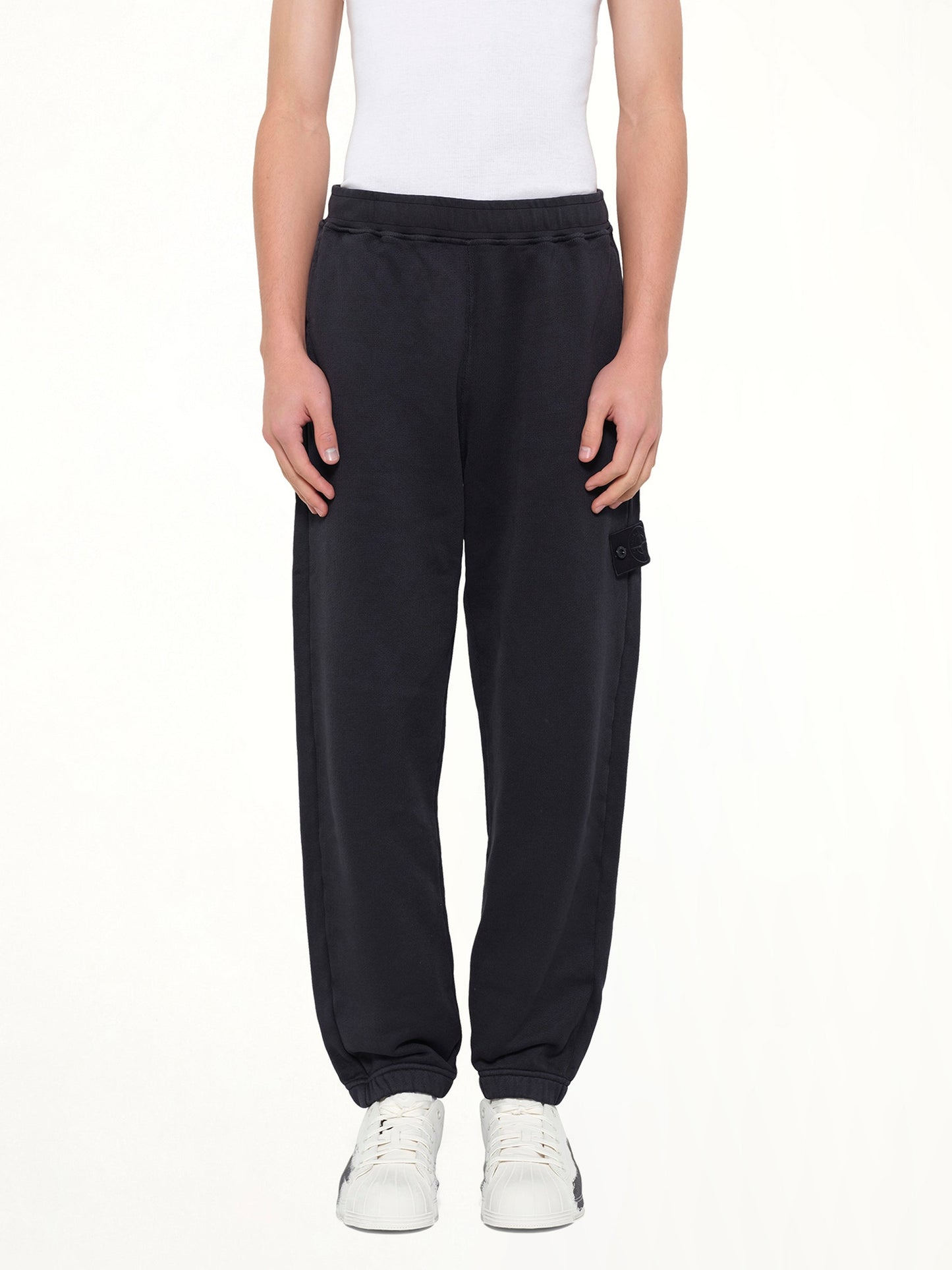 Image of a model wearing Pants. Product name - 6200008 Sweat Pants in Navy colour by brand - STONE ISLAND