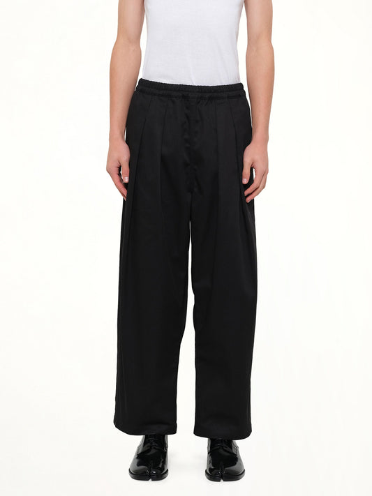 Image of a model wearing Pants. Product name - Cropped Chino Pants in Black colour by brand - MAISON MARGIELA
