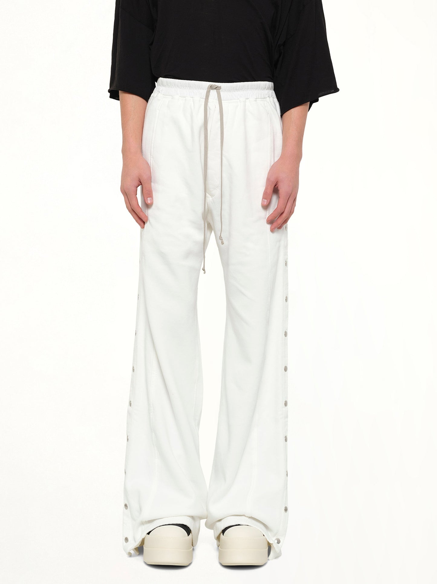 Image of a model wearing Pants. Product name - Wide Pusher Pants in White colour by brand - RICK OWENS DRKSHDW