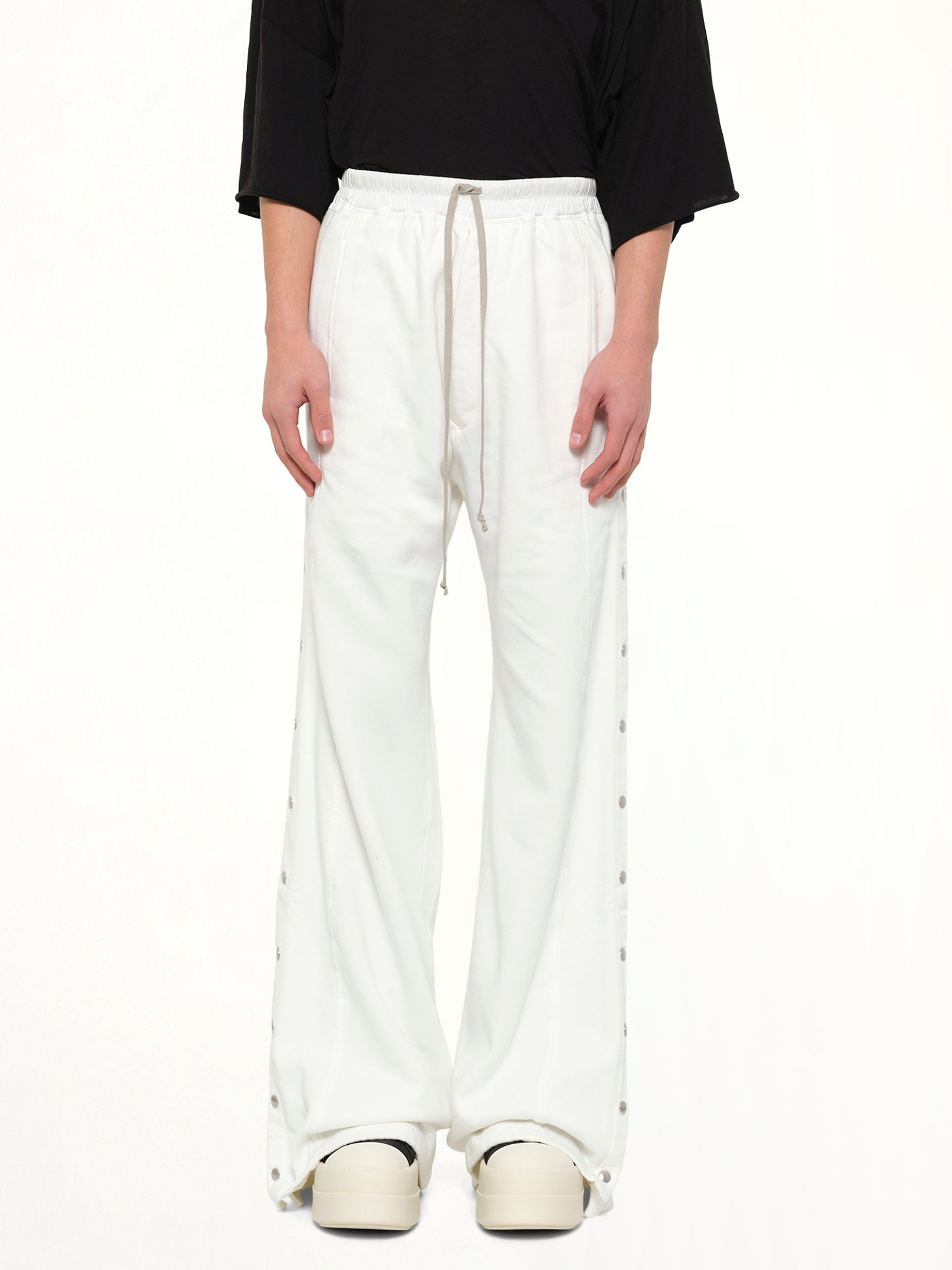 Image of a model wearing Pants. Product name - Wide Pusher Pants in White colour by brand - RICK OWENS DRKSHDW