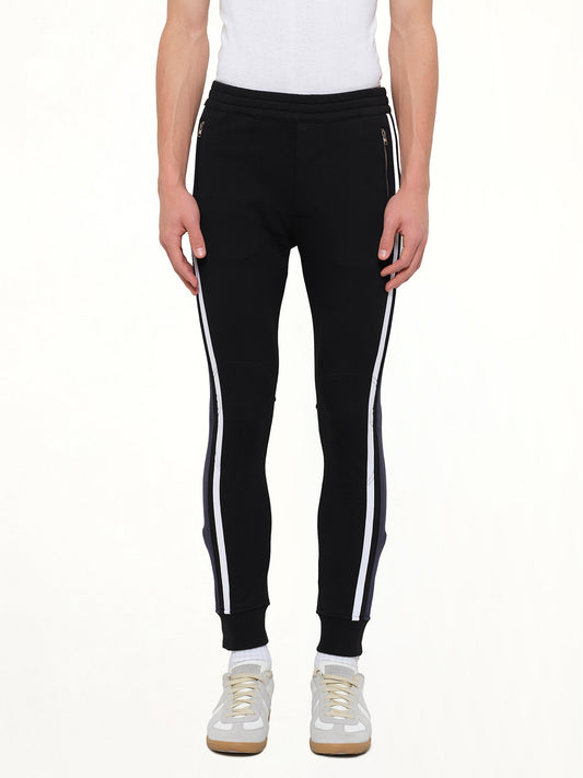 Image of a model wearing Pants. Product name - Embroidered Sweat Pants in Black colour by brand - ALEXANDER MCQUEEN