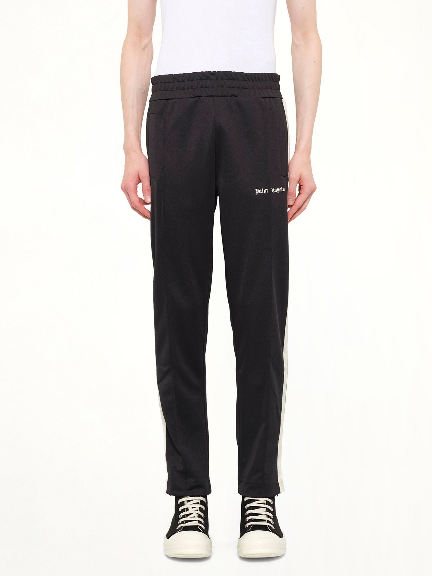 Image of a model wearing Pants. Product name - Classic Logo Track Pants in Black colour by brand - PALM ANGELS