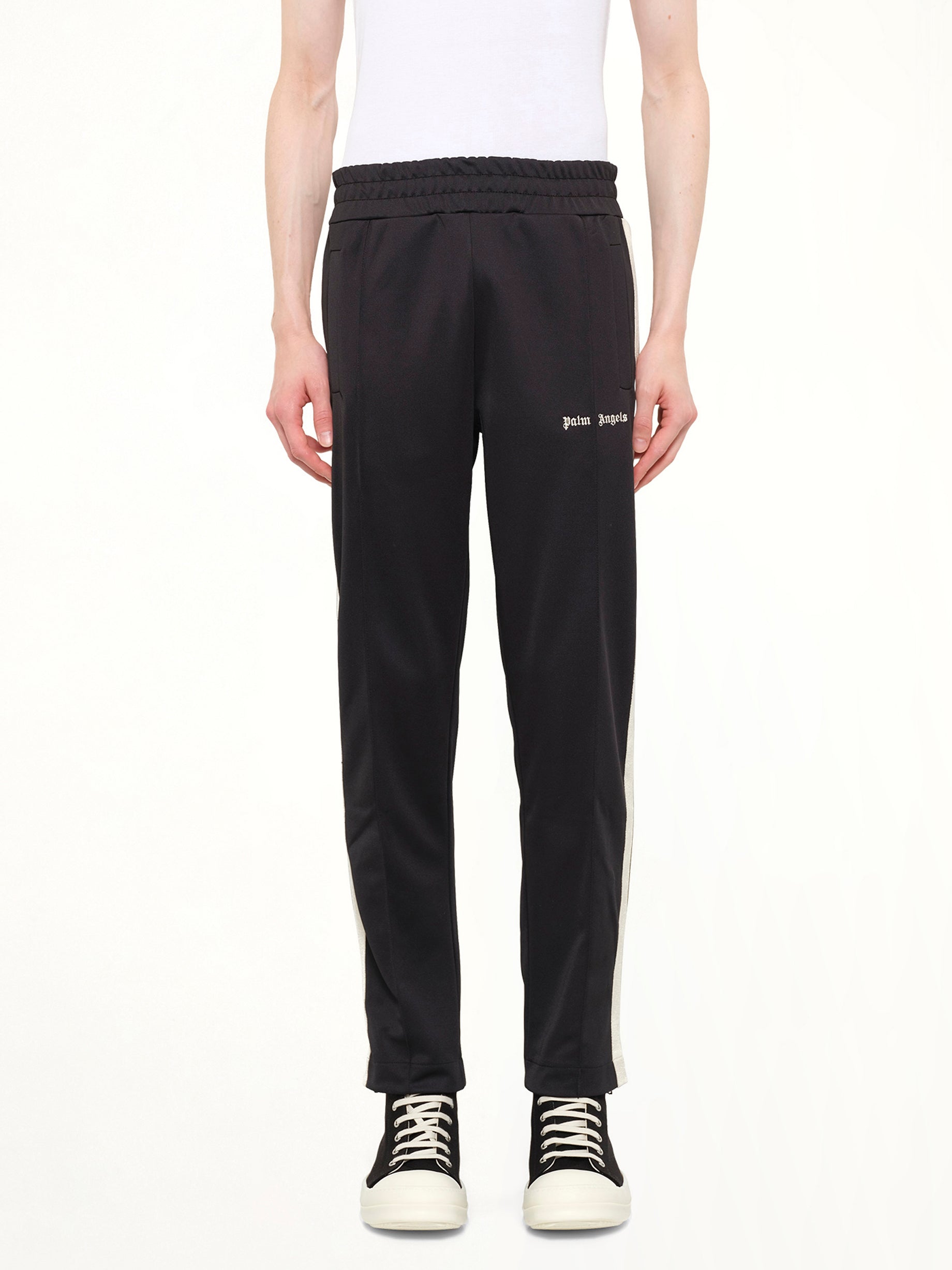 Image of a model wearing Pants. Product name - Classic Logo Track Pants in Black colour by brand - PALM ANGELS