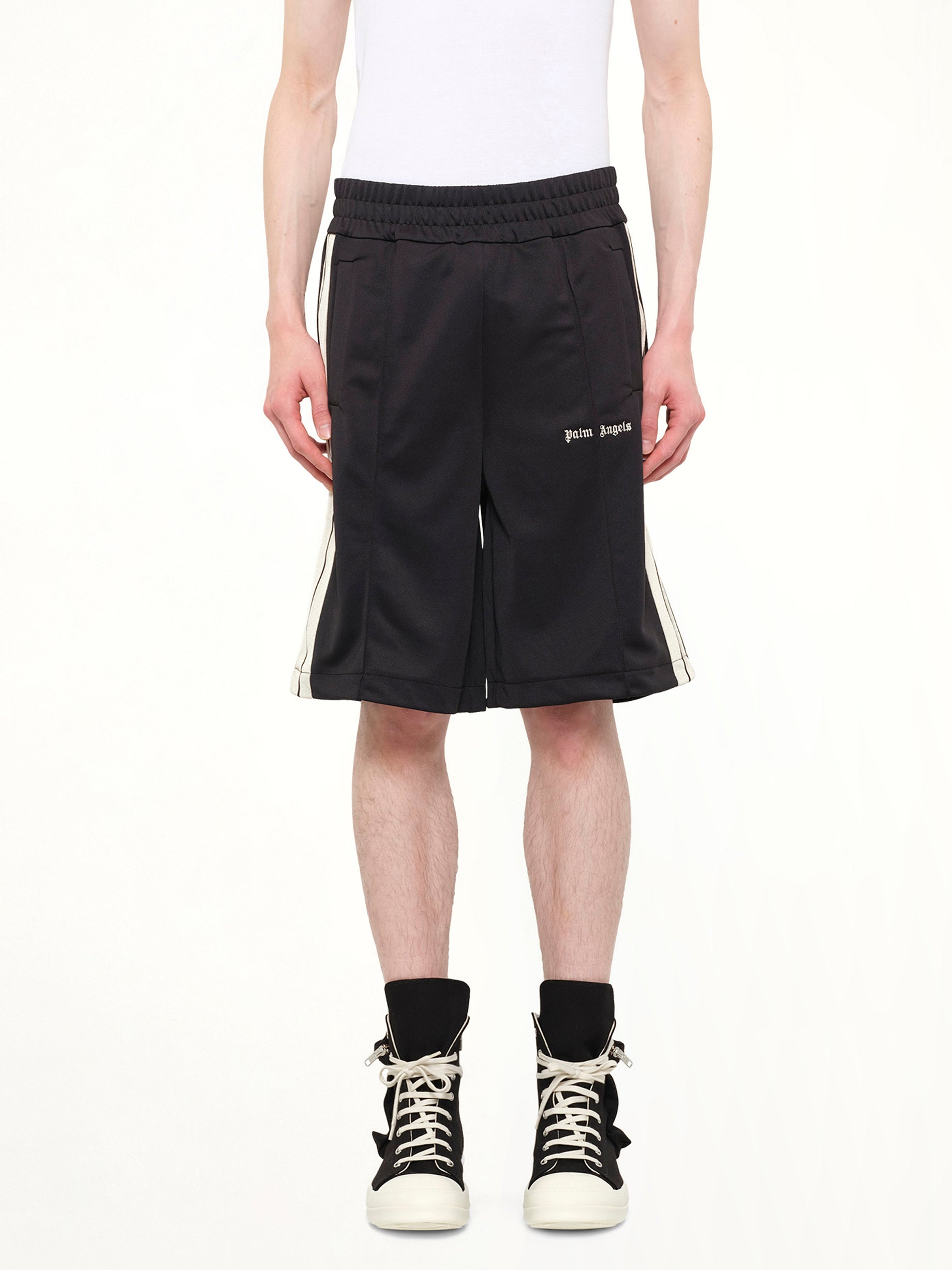 Image of a model wearing Shorts. Product name - Classic Logo Track Shorts in Black colour by brand - PALM ANGELS