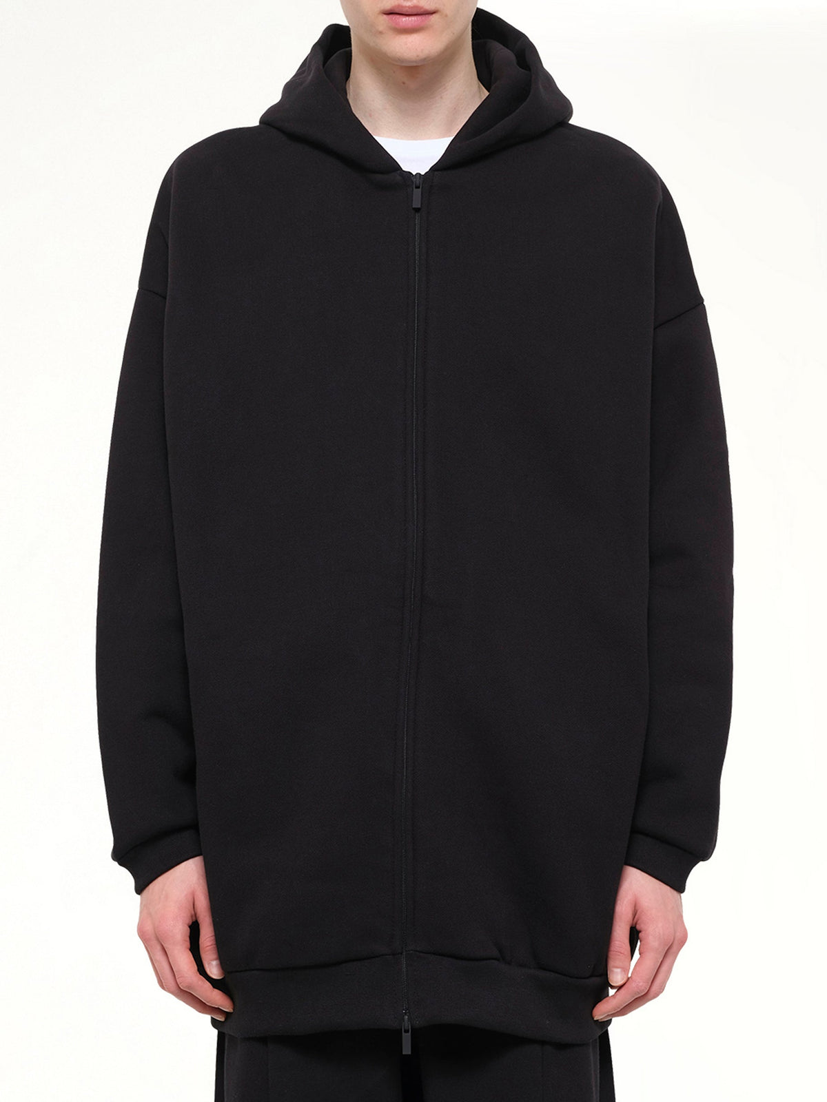 Image of a model wearing Outerwear. Product name - Property Lounge Long Zip Hoodie in Black colour by brand - FEAR OF GOD ESSENTIALS