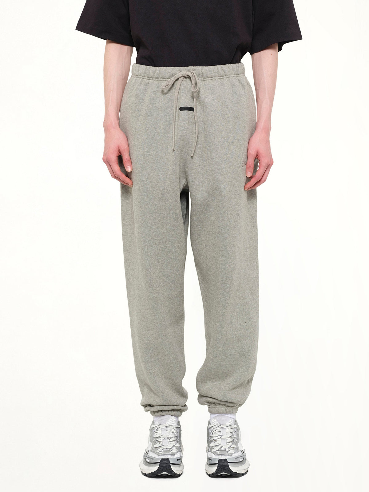 Image of a model wearing Pants. Product name - Signature Classic Sweatpant in Grey colour by brand - FEAR OF GOD ESSENTIALS