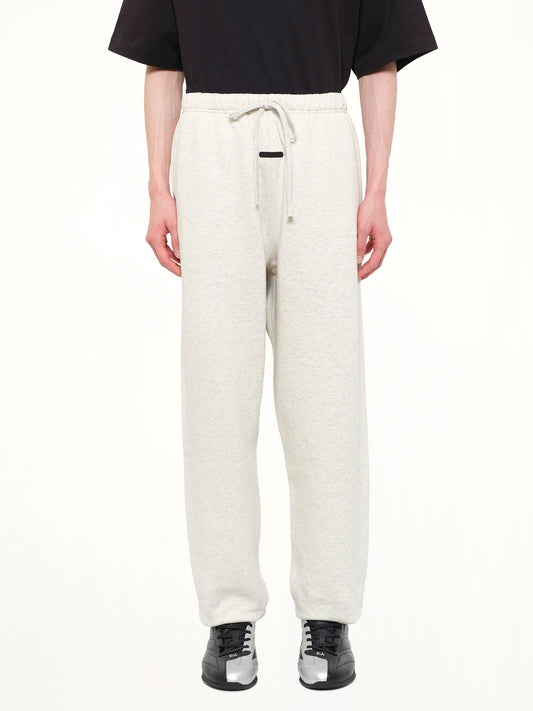 Image of a model wearing Pants. Product name - Signature Classic Sweatpant in White colour by brand - FEAR OF GOD ESSENTIALS