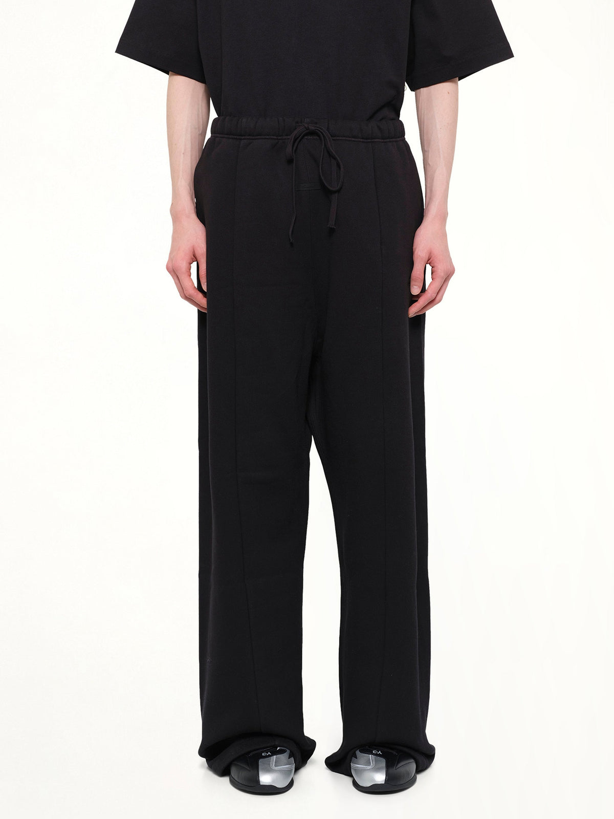 Image of a model wearing Pants. Product name - Signature Lounge Sweatpant in Black colour by brand - FEAR OF GOD ESSENTIALS