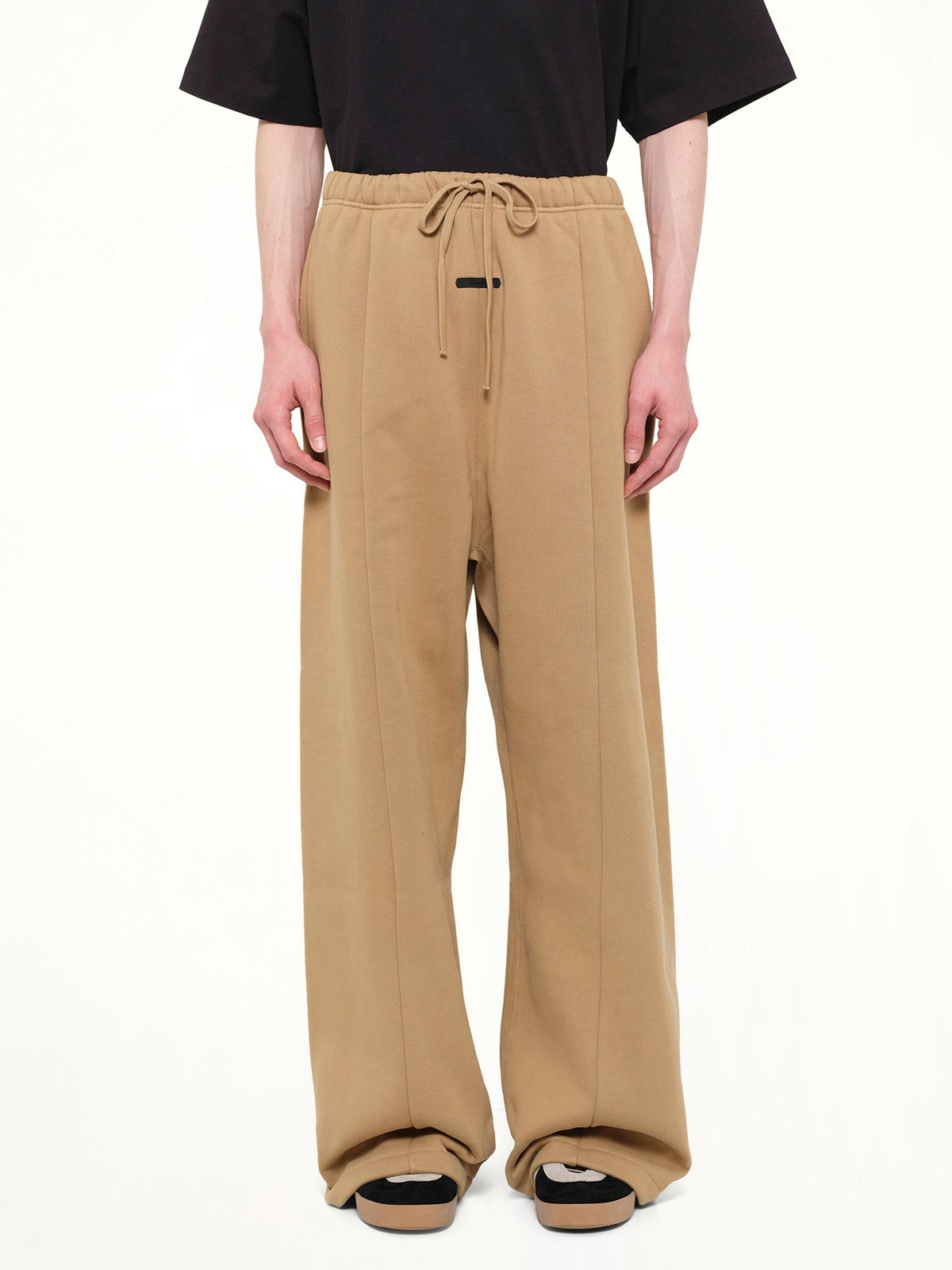 Image of a model wearing Pants. Product name - Signature Lounge Sweatpant in Brown colour by brand - FEAR OF GOD ESSENTIALS