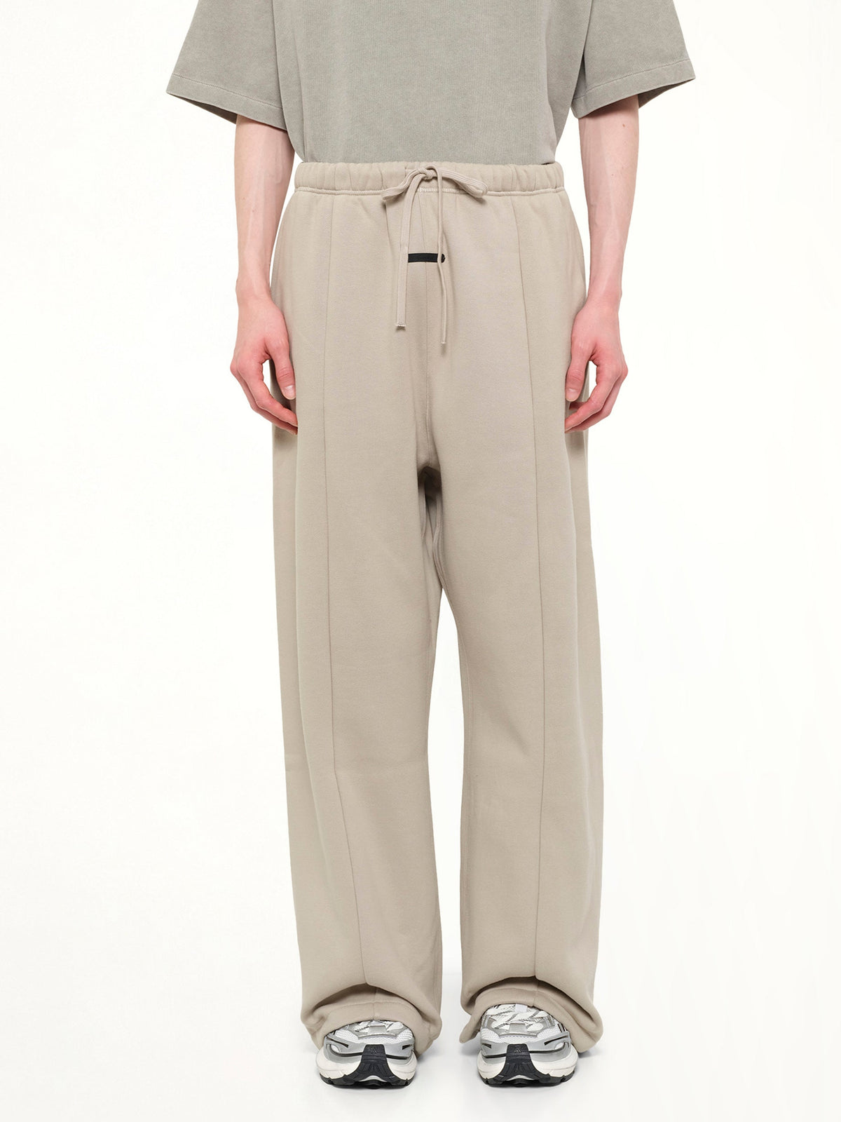 Image of a model wearing Pants. Product name - Signature Lounge Sweatpant in Grey colour by brand - FEAR OF GOD ESSENTIALS