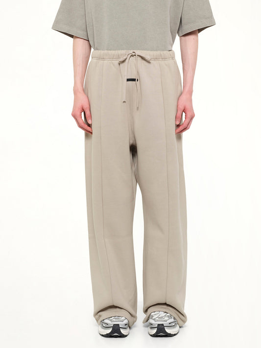 Image of a model wearing Pants. Product name - Signature Lounge Sweatpant in Grey colour by brand - FEAR OF GOD ESSENTIALS
