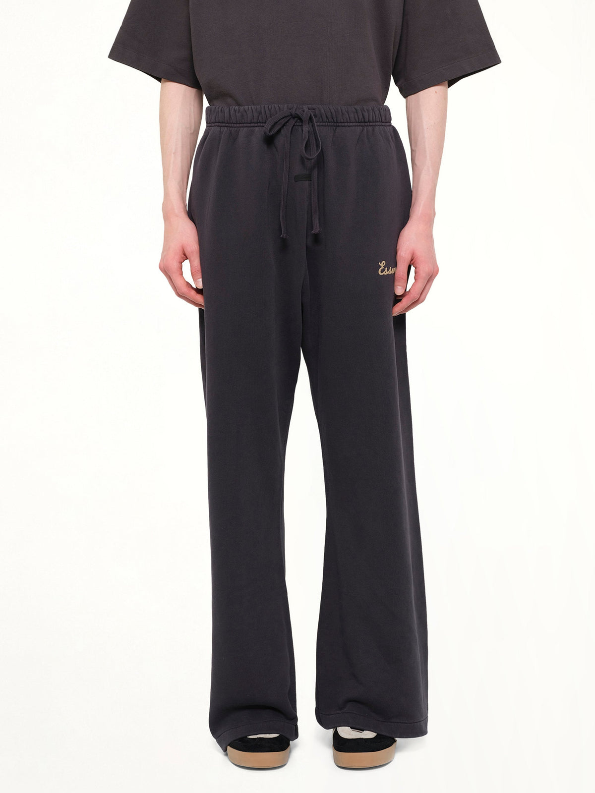 Image of a model wearing Pants. Product name - Training Classic Fit Flare Sweatpant in Black colour by brand - FEAR OF GOD ESSENTIALS
