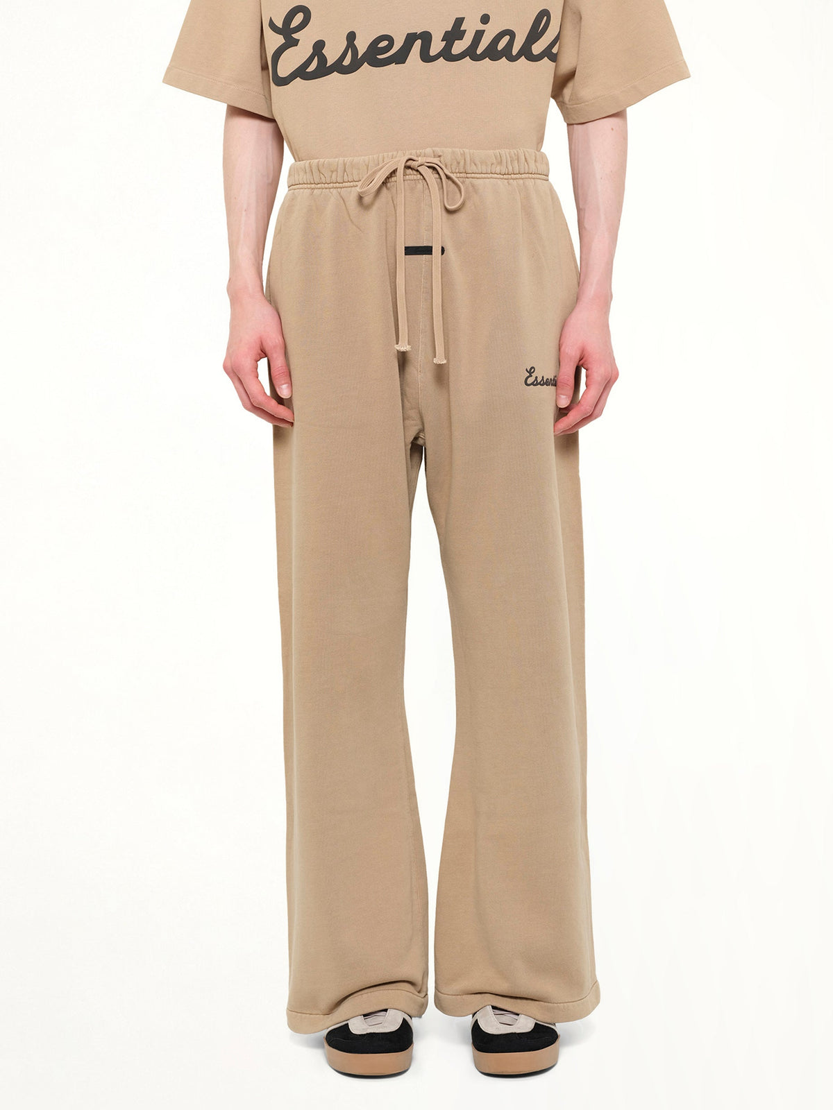 Image of a model wearing Pants. Product name - Training Classic Fit Flare Sweatpant in Brown colour by brand - FEAR OF GOD ESSENTIALS