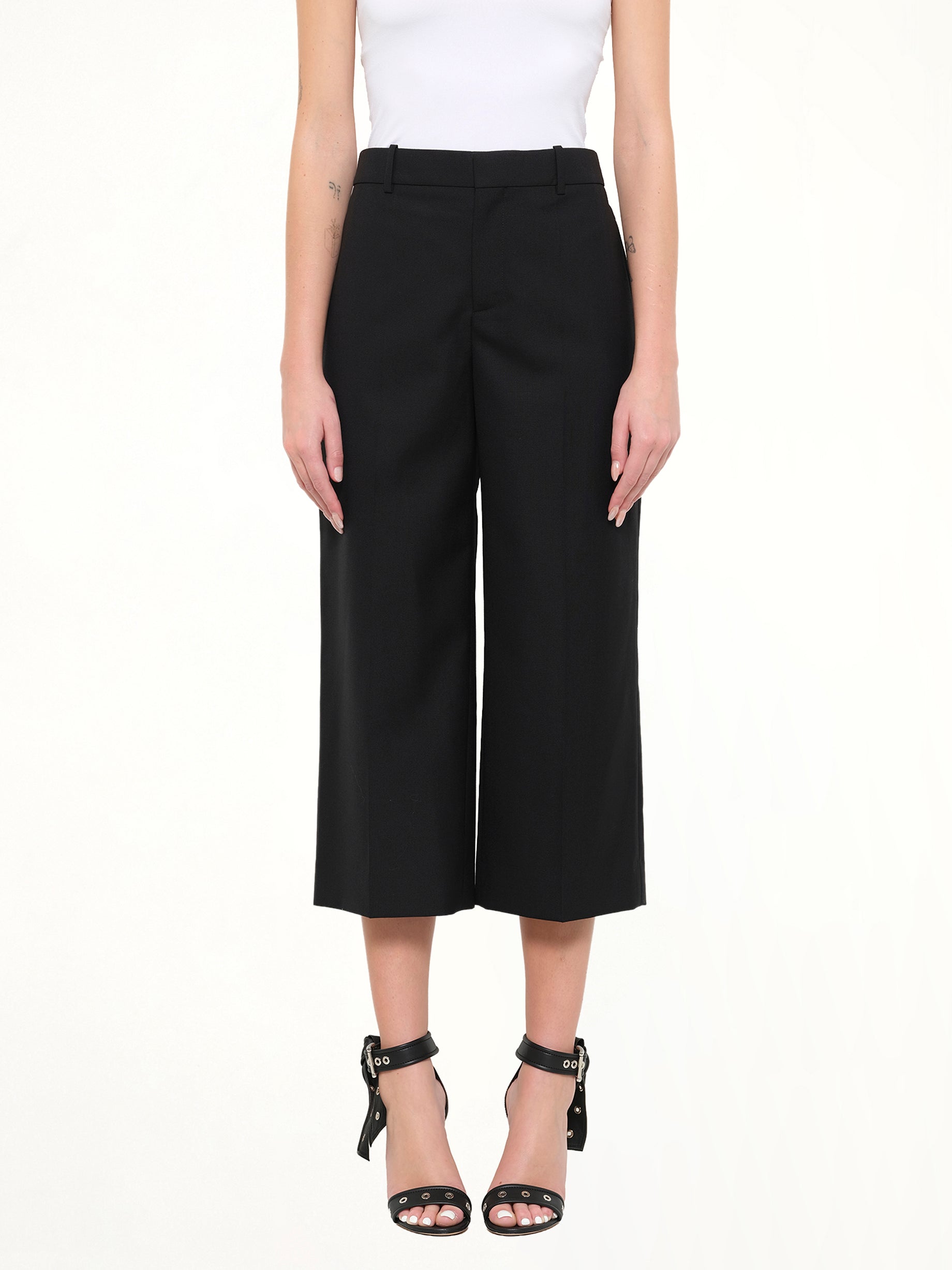 Image of a model wearing Pants. Product name - Short Wool Pants in Black colour by brand - GIVENCHY