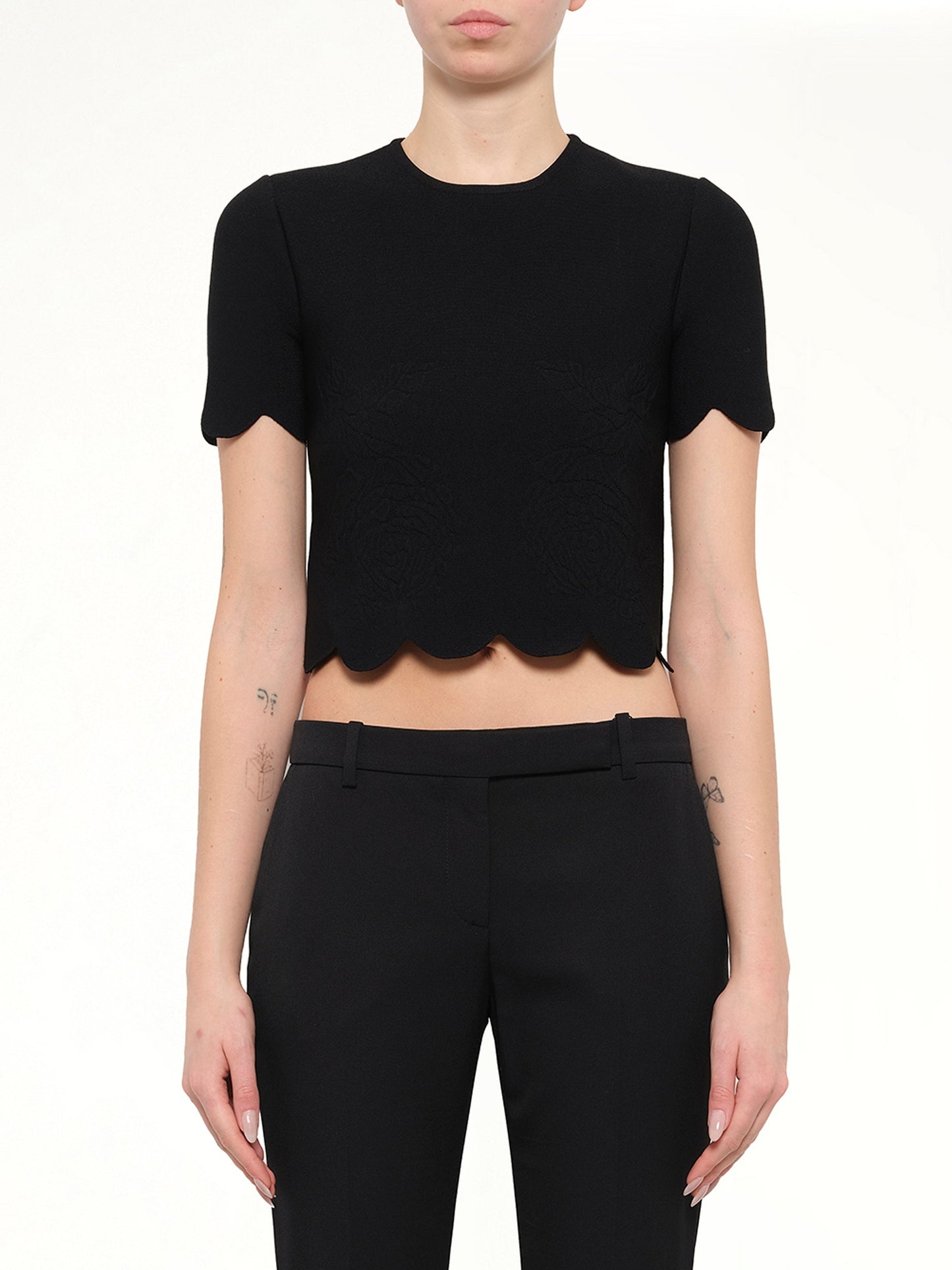 Image of a model wearing Tops. Product name - Alexander McQueen Embellished Rose Top in Black colour by brand - ALEXANDER MCQUEEN