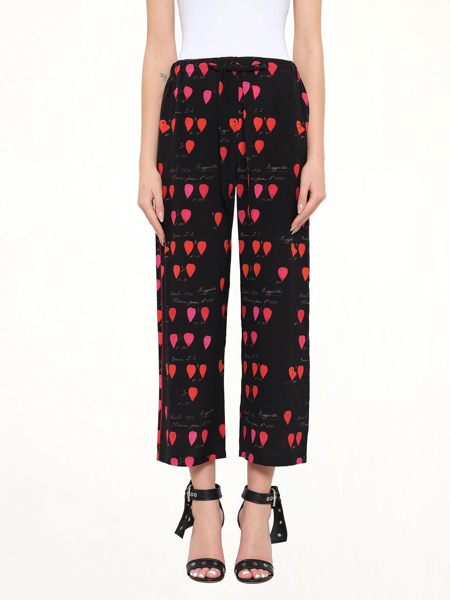 Image of a model wearing Pants. Product name - Alexander McQueen Petal Print Pants in Black colour by brand - ALEXANDER MCQUEEN