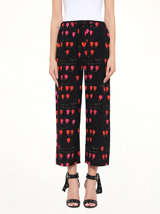 Image of a model wearing Pants. Product name - Alexander McQueen Petal Print Pants in Black colour by brand - ALEXANDER MCQUEEN