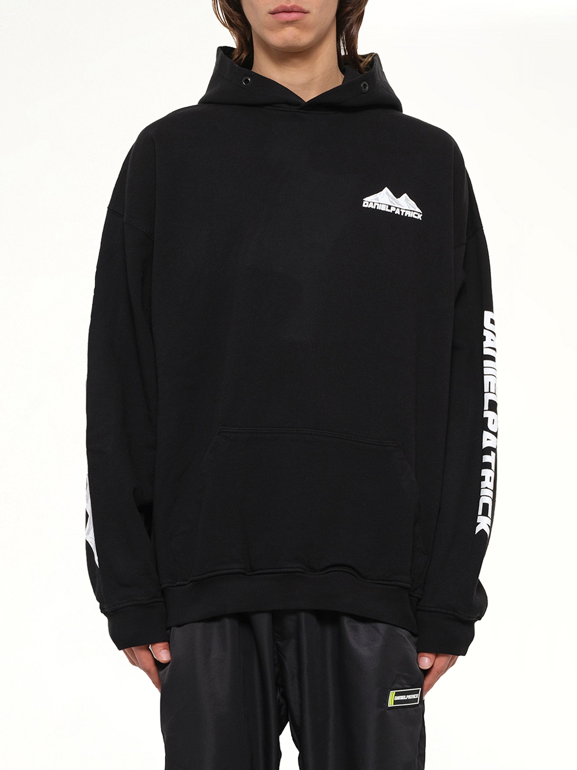 Image of a model wearing Outerwear. Product name - Moving Mountains Hoodie in Black colour by brand - DANIEL PATRICK