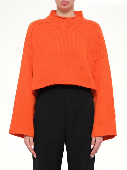 Image of a model wearing Outerwear. Product name - Cable Detail Knit in Tang colour by brand - JWA