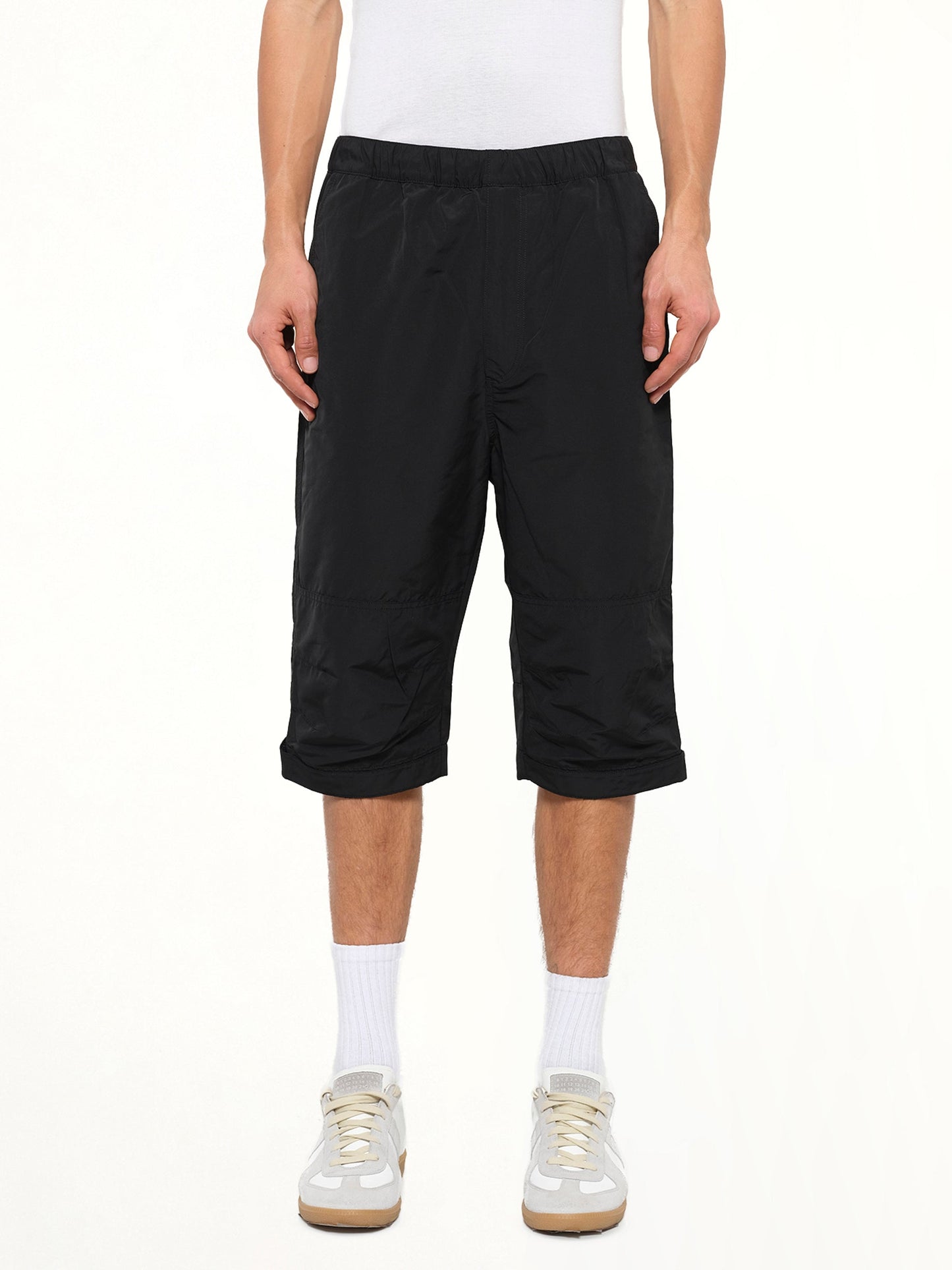 Image of a model wearing Shorts. Product name - Long Stretch Waist Shorts in Black colour by brand - GIVENCHY